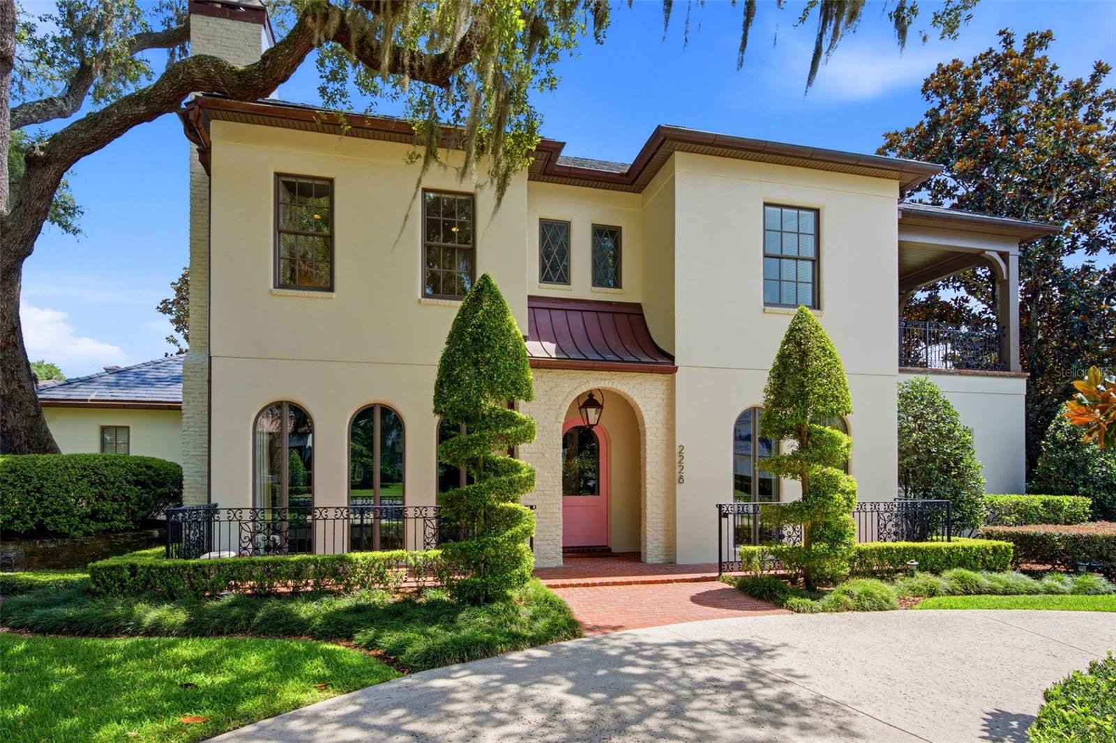 This elegant transitional French Provincial residence is located on a large, elevated corner lot in a quiet and secluded area in the Via’s of Winter Park. This residence has been significantly enhanced inside and out by the current owner. The home features 5,200 square feet of living space and 800+ square feet of outdoor space with 5 bedrooms, 5 bathrooms ensuite, 1 half bathroom, 3 car garage, pool, patio and professionally landscaped yard and lighting. Upon entry, you are welcomed through the exquisite foyer where you instantly notice the craftsmanship and expert care that went into the custom carpentry and crown molding details throughout. To the left of the foyer is an elegant and intimate parlor with grass cloth wallpaper, a gas vented fireplace and built-in bookshelves. To the right of the foyer is the formal dining room with beautiful hand painted wallpaper and an adjacent butler’s pantry. Past the foyer you are led to a spacious and grand formal living room with 6 new French iron doors that flow out to a covered brick porch and picturesque back yard & pool. Designed with entertainment in mind, the adjoining chef’s kitchen includes newly painted custom cabinetry, a Sub-Zero/Wolf appliance package, a grand center island and a walk-in pantry. Built in desk and casual dining area all open to the adjoining beamed ceiling family room with gas vented fireplace and additional French doors that lead to street side patio with new awnings. First floor master retreat overlooks the pool & yard and features 14-foot wood beam vaulted ceilings. The oversized master bath with double custom lacquered vanities made in Palm Beach, mosaic marble shower and a Waterworks free standing tub, brushed brass fixtures, and walk in closet. The second-floor features nine-foot ceilings with four bedrooms (one which was converted to a beautiful women’s dressing room) and four ensuite bathrooms, covered balcony adjoining two bedrooms, two built in desks and bookshelves for office/study time and large media room with big screen tv and wet-bar. There are also two laundry rooms, one upstairs and one downstairs. Attic space inside the home and inside the garage. Recent upgrades include slate roof/swooped decorative copper roof with chimney caps, complete chimney rebuild, nine iron French doors, white oak tongue and grove hardwood floors, renovated master bath and two ensuite baths, two new HVAC home units and a new garage mini-split air conditioner. This home offers boat access to the Winter Park chain of lakes and is within short distance of the Winter Park Racquet Club. It’s also a bike ride away and a short drive to the Interlachen Country Club and Park Avenue shopping and dining district. The property is zoned for Dommerich Elementary, Maitland Middle School, and Winter Park High School. One or more rooms virtually staged