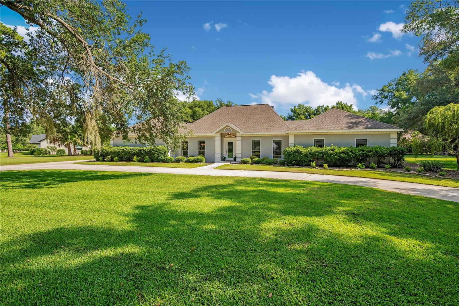 Save Big: 1% lender credit (based on loan amount) toward closing costs or rate buy-down with seller’s preferred lender. Ask for details! Welcome to this beautifully maintained custom home located in the highly sought-after gated community of River Crest. Surrounded by mature trees and quiet streets, this intimate enclave of just 120 homes offers a rare blend of privacy, charm, and convenience. Just minutes from top-rated Seminole County schools, shopping, and major commuter routes.

Set on a private one-acre lot, this single-story residence offers over 3,700 sqft with 4 bedrooms and 3 baths, designed with timeless detail throughout. A circular driveway framed by grand oak trees and lush landscaping creates a striking first impression, leading to a glass entry that sets the tone for the home’s classic elegance.

Inside, you’ll find a light-filled formal dining room, private office, and a spacious kitchen featuring white cabinetry, black granite countertops, tiled backsplash, and a center island. The newer oven/microwave combo enhances the space, with room for the next owner to bring their own vision to the surrounding cabinetry and design. The open living room impresses with soaring ceilings and a floor-to-ceiling stone fireplace, all overlooking the beautiful pool and outdoor living space.

The split floor plan offers a private owner’s suite with a spa-style bath featuring dual vanities, a garden tub, and walk-in shower. Three additional bedrooms, a designated office, and large bonus room provide flexibility for guests, work, and entertainment.
Step outside to a private backyard retreat with a sparkling pool, paver decking, and mature landscaping.

River Crest is a 24-hour gated, guarded community offering a private tennis court, and a scenic park with boardwalk access leading to the Wekiva River. Conveniently located near the 4-29, 4/-17, and I-4, the Lake Mary business district, Seminole Wekiva Trail, and local parks, this home delivers the perfect balance of lifestyle, location, and luxury.