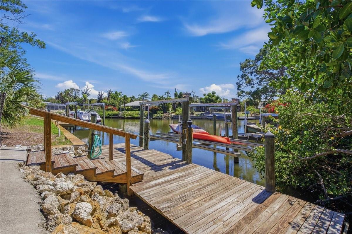 SIGNIFICANT PRICE REDUCTION:  HIGHLY DESIRABLE OFFERING IN THE WATERFRONT COMMUNITY OF THE LEMON BAY SUNSET SUBDIVISION.  Have you always dreamed of owning a home with "backyard" access to your own boat and dock with easy access from the Intracoastal to the Gulf of Mexico-but thought it would be unattainable? The thought of hurricanes gives you pause? Well wish no longer-as this is the one that will be difficult to walk away from. Meticulously updated and maintained this 2280 sq. ft., 0.40 acre pie-shaped, fenced corner lot home lives much larger than its square footage and has never suffered any hurricane associated damage. With its bright and oversized rooms that draw you in to enjoy the indoor/outdoor all-season living that draws over 1000 people per day to make Florida their home you will delight in the "find" you can call your own. The outdoor lanai with heated swimming pool is surrounded by lovingly tendered Florida mature plantings and leads to the pathway to your 2 year young replaced boat dock and access stairs. The boat lift can accommodate a vessel that is between 8000-10000 lbs. while the depth of the Lemon Bay Canal can handle a craft of up to 45 ft. The owners show pride of ownership in the manner in which the house has been maintained. Newer roof, 2025 hot water heater with newer replaced dual zone A.C. units {2023 and 2025} and a generator hookup only ads to its worry free enjoyment. High impact windows and doors reinforces the inclement weather-hardening of the home. The Owners did not stop there: Kitchen cabinets and counter-tops with a reverse osmosis system, appliances, laundry room with cabinets with utility sink, luxury CORTEC waterproof flooring, bathrooms remodeled and the popcorn ceilings were replaced with a texturized product. In addition the house had been re-plumbed in 2024 where the pipes have been run above the ceilings. There are two wells on the property. Only one is utilized for irrigation with a new freshwater connector switch. The den and family room share in a prominent custom-installed pass through fieldstone wood-burning fireplace which adds to the laid back ambience of the home and in particular the most used rooms in the home. The oversized garage is home to the owner's workshop when the "I can fix it" need comes up. Freshly painted, crown molding, French doors, plantation shutters throughout plus the new fans add to the crispness of the room presentations and the well thought out floor plan flow. Bringing the family?  After fishing swimming and boating there is an abundance of places to ride your bikes and enjoy the ride to the Lemon Bay Park just down the road.   *Don't miss this beautiful waterfront home.*