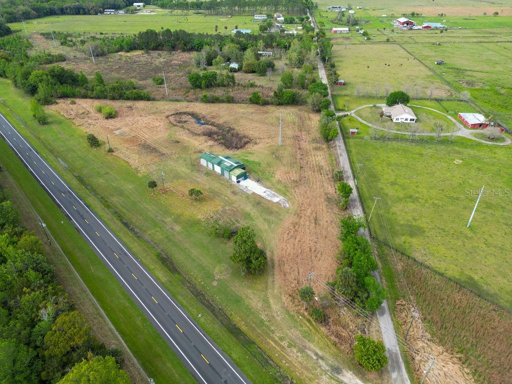 Discover the perfect blend of space, versatility, and country living at 6029 US Highway 17 in DeLeon Springs! This beautifully cleared 3.32-acre property is ready for your vision—whether you’re looking to build your dream home or place a manufactured or modular home. With no flood insurance required, you can enjoy peace of mind while planning your future. The property features an impressive 2,200 sq ft aluminum building on a solid concrete slab, complete with two large bay doors and three additional smaller bay doors—ideal for storing equipment, running a business, or housing all your toys. An additional concrete pad provides even more flexibility for expansion or outdoor use. Enjoy the natural charm of two ponds on the property, adding both beauty and tranquility to your surroundings. Zoned agricultural, this property welcomes your animals, recreational vehicles, and outdoor lifestyle. With ample space, functional structures, and endless potential, this is your opportunity to create the lifestyle you’ve been dreaming of!