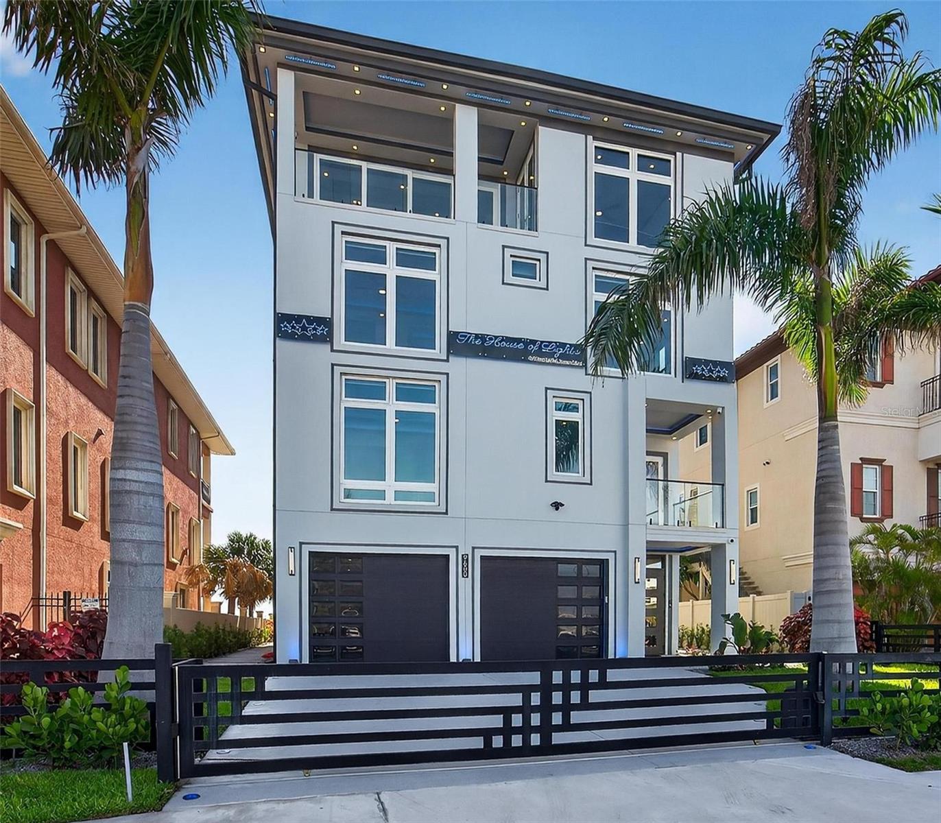 9600 Gulf Blvd | The House of Lights
5 Beds | 7 Baths | Rooftop Infinity Pool | 4-Car Garage | 5,198 Sq Ft Living | Smart Home

Florida beachfront living begins here. 9600 Gulf Blvd is a custom-built 2025 modern coastal home located in the heart of Treasure Island. This 5-bedroom, 7-bath home offers over 5,198 square feet of living space and is constructed entirely of concrete—including post-tension concrete floors on every level and a full concrete roof. Built on a deep piling foundation extending up to 45 feet into the ground, the home offers structural integrity rarely seen in residential construction. The main living floor is elevated 18 feet above sea level. Premium closed-cell and spray foam insulation ensure high efficiency, and a 32kW Generac whole-home generator adds peace of mind. Behind a private gate, the ground level includes a spacious air-conditioned garage that fits 3 or more cars and features three Tesla chargers. A covered lounge area with an outdoor shower makes it easy to rinse off after a beach walk.

Inside, the main level features a wall of glass, open living and dining areas, and a chef’s kitchen with gas appliances, double ovens, pot filler, espresso machine, wine fridge, custom backsplash, and oversized butler’s pantry with a secondary fridge. A guest suite with walk-in closet and full bath, plus a powder bath, complete this level.

The third floor includes a second living room, two additional private suites, another guest bedroom, and the spacious primary suite with dual custom closets, balcony access, and a spa-style bathroom with a large dual rain head shower.

The fourth-floor rooftop includes a stainless steel and acrylic infinity-edge pool, expansive lounge areas, a full outdoor kitchen, and a flexible indoor room perfect for a media setup, gym, or entertaining. There’s also a private office or optional sixth bedroom.

Additional features include a glass elevator, seamless fire-rated interior doors, a smart home server system, and full gas appliances. With no HOA and no CDD, this home offers rare flexibility on Florida’s Gulf Coast—just minutes from dining, shopping, and major access routes