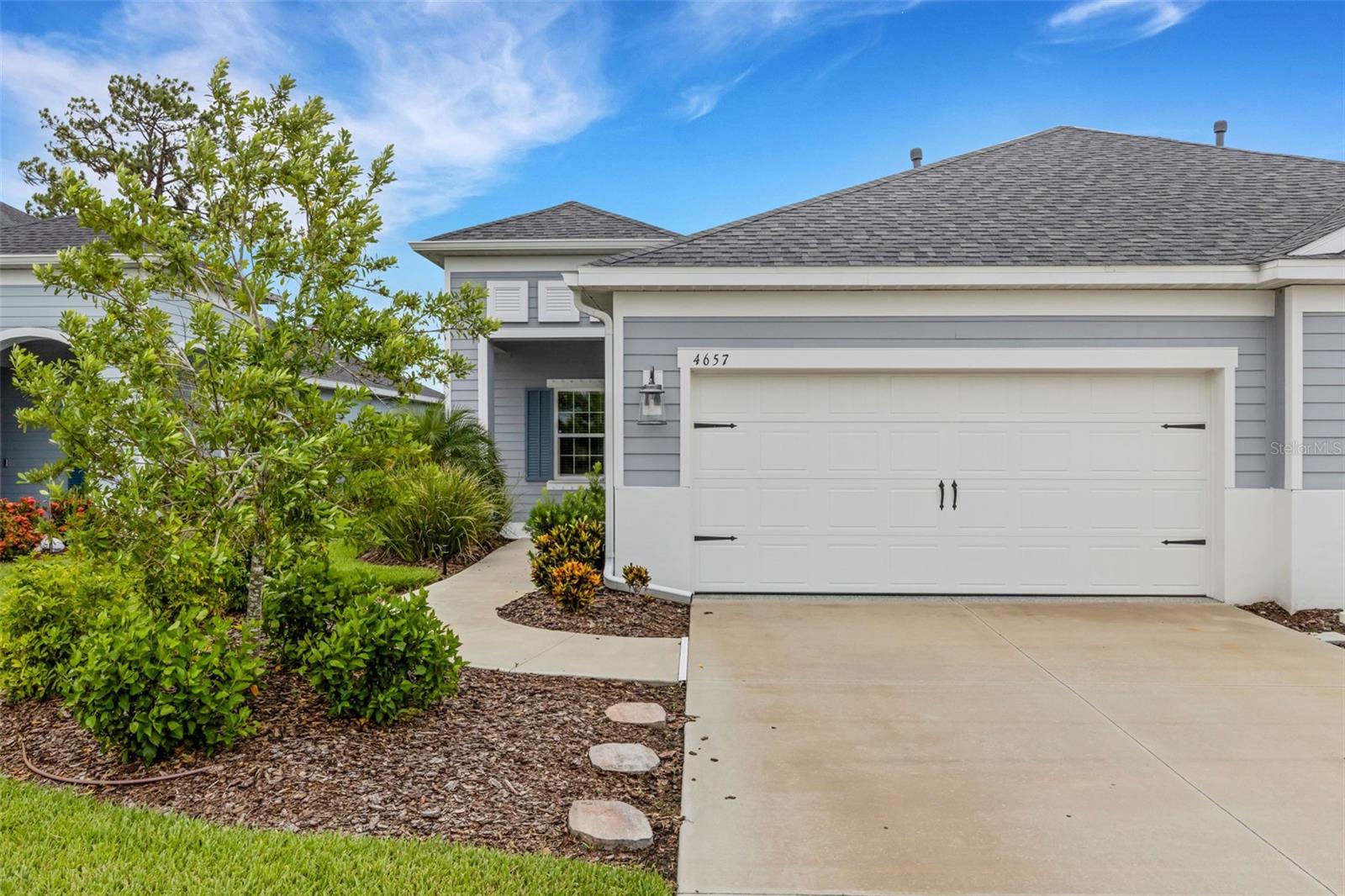 Welcome to easy Florida living in the heart of up-and-coming Parrish! This beautifully upgraded 2-bedroom, 2-bath villa is only 3 years old and offers 1,525 square feet of stylish, low-maintenance living. Step inside and you'll immediately notice the gorgeous oversized tile flooring, upgraded light fixtures, 2-inch wood blinds, and elegant tray ceiling in the living room. The spacious kitchen is designed for both everyday living and entertaining, featuring a large center island, gas range, pantry with custom made door, and an abundance of cabinets and drawers for exceptional storage.
The primary suite is a relaxing retreat featuring a beautiful wood accent wall, two closets—including a spacious walk-in closet—a dual-sink vanity, and a large walk-in shower. The living area is equally impressive with a stunning TV accent wall and fireplace, creating a warm and inviting focal point. Enjoy Florida's indoor-outdoor lifestyle from the large screened lanai, perfect for morning coffee, evening cocktails, or entertaining friends. The extended lanai and garage both feature durable epoxy flooring, while additional garage storage helps keep everything organized.

A RARE OPPORTUNITY! The attached villa next door (D6148147) is also available for purchase, creating a unique chance to own both sides! Imagine the possibilities—live in one villa and use the other as a potential rental or investment property, create the perfect multi-generational living arrangement with parents on one side and adult children on the other, or keep family and friends close while everyone enjoys the privacy and independence of their own home. Whether you're planning for extended family, looking for additional income potential, or simply want the flexibility that owning two neighboring residences can provide, opportunities like this don't come along often!

The location within the neighborhood couldn't be more convenient—you'll be directly across the street from the community pool and mailboxes! Just across the road, residents also enjoy access to the amenities at Canoe Creek, including an additional larger pool, pickleball courts, a state-of-the-art fitness center, community room, walking trails, 2 dog parks and so much more. Parrish is one of Florida's fastest-growing Gulf Coast communities, offering a relaxed lifestyle while keeping you within easy reach of shopping, dining, entertainment, and some of the area's most popular destinations. Spend your days exploring the beautiful Gulf Coast beaches of Anna Maria Island, St. Pete Beach, and Siesta Key, then come home to your own peaceful Florida retreat. Whether you're looking for a full-time residence, seasonal getaway, or simply a low-maintenance home where you can enjoy the Florida lifestyle, this move-in-ready villa is ready to welcome you home!