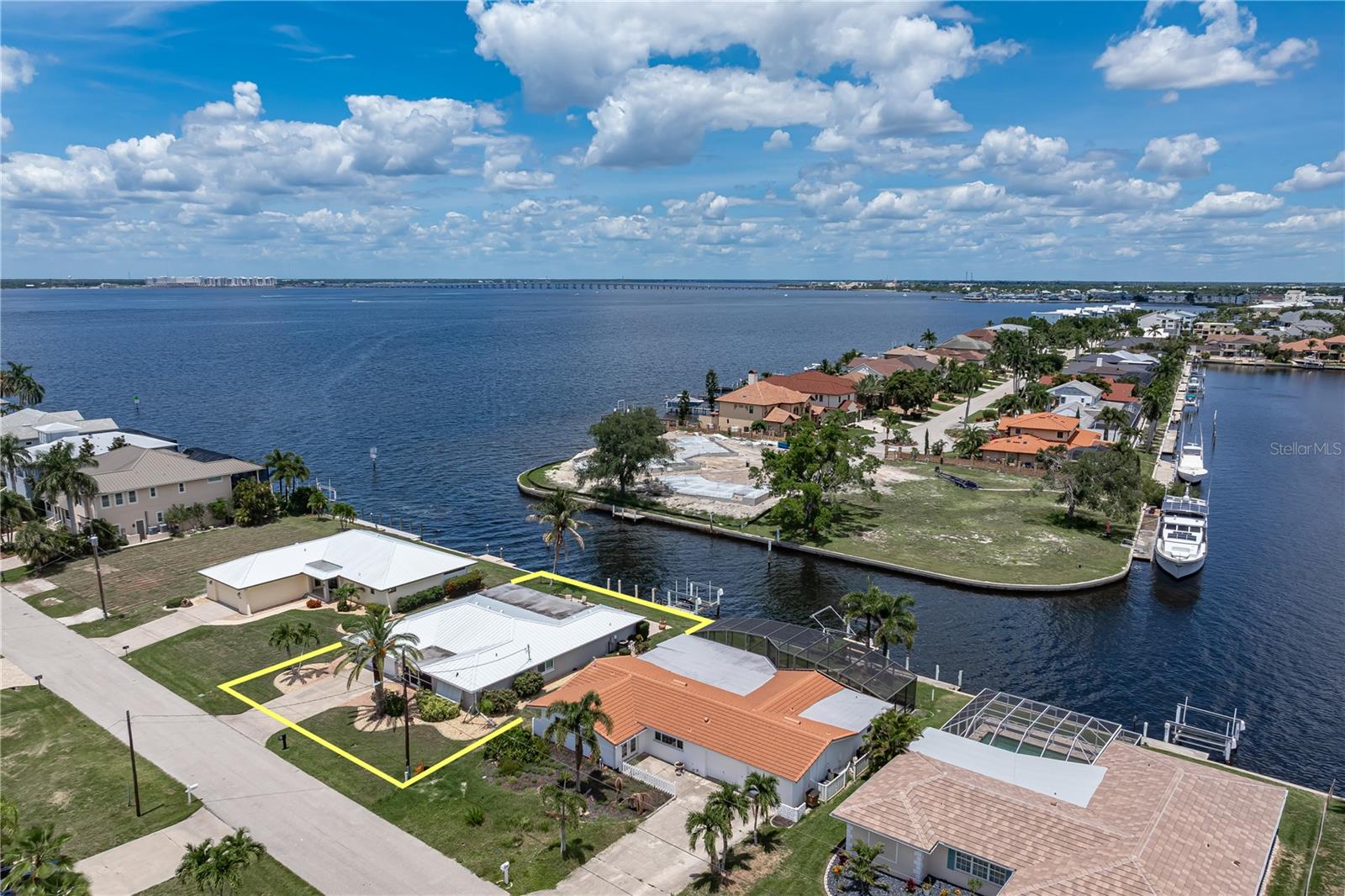 BOATER'S DREAM - JUST MINUTES TO OPEN WATER W/NEW METAL ROOF, 80FT OF SEAWALL & SPECTACULAR HARBOR VIEWS - Experience some of the quickest boating access in all of Punta Gorda Isles from this beautifully updated 3 bed/2 bath waterfront home offering 2,480 square feet of living space, 80 feet of seawall, a 30-foot concrete dock, 10,000 lb boat lift, and near-instant sailboat access to Charlotte Harbor. Located just a few lots from open water, the property enjoys exceptional views of intersecting canals and the harbor beyond, creating a constantly changing backdrop of passing boats, dolphins, and unforgettable Florida sunrises. Inside, the home blends modern coastal style with spacious, light-filled living areas designed around the water views. Large picture windows stretch across the rear of the home, flooding the expansive family room with natural light while showcasing the spectacular waterfront setting. The open, renovated kitchen serves as the heart of the home with quartz countertops, white shaker cabinetry, stainless steel appliances, subway tile backsplash, oversized breakfast bar seating, and a built-in desk area. Light wood-look tile flooring, crown molding, recessed lighting, and a soft coastal color palette continue throughout the home. The layout offers multiple gathering spaces including a large formal living room and an oversized Florida room, creating flexibility for entertaining family and friends. The private master suite features water views and a beautifully updated spa-inspired bath with dual vanities and an oversized walk-in shower with designer tile finishes. Two generously sized guest bedrooms share an updated guest bath - perfect for hosting out-of-town guests. Step outside to your own waterfront oasis. The brick paver pool deck surrounds the in-ground, heated saltwater pool, creating the perfect setting for relaxing after a day on the water or hosting weekend gatherings. Just beyond the pool, the dock and lift are ready for your boat, allowing you to reach Charlotte Harbor in mere minutes and enjoy some of the finest boating, fishing, and waterfront dining Southwest Florida has to offer. Recent updates include a NEW metal roof (2023), newer A/C system (2021) and whole-house impact-resistant windows. Hurricane shutters and panels remain in place, providing an additional layer of storm protection and peace of mind. Other features include well-maintained tropical landscaping, a screened front porch and an attached 2-car garage. Punta Gorda Isles is one of Southwest Florida's premier boating communities, offering miles of sidewalks, nearby golf, waterfront parks, pickleball and tennis courts, yacht clubs, Fishermen's Village, and historic downtown Punta Gorda's restaurants, shopping, and entertainment. While Punta Gorda is renowned for its boating lifestyle, the city also boasts a vibrant arts and music scene. Spend weekends exploring local farmers markets, strolling through art fairs, enjoying waterfront festivals, and attending live music events held throughout the year. Whether your perfect day involves time on the water or an evening downtown, Punta Gorda offers an active and engaging lifestyle for every interest. Make an appointment today and start living the waterfront lifestyle you've been dreaming about.