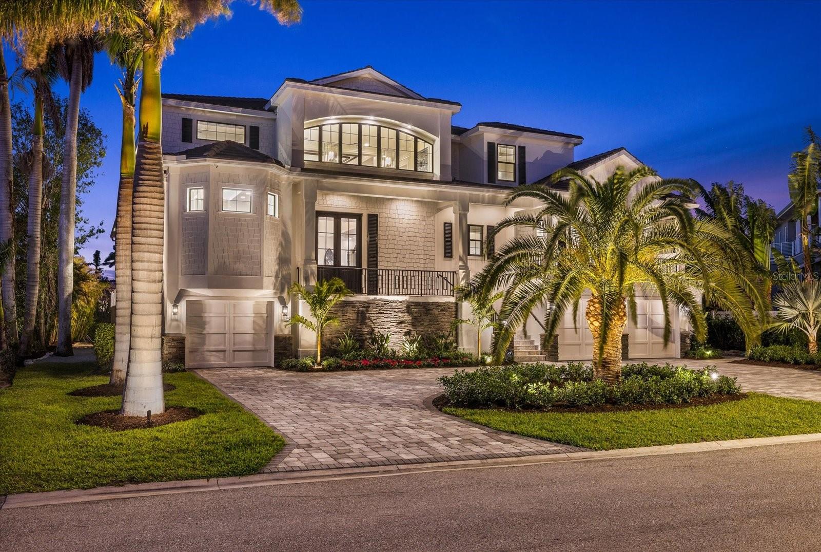 A true masterpiece of modern coastal design, this custom-built 2021 waterfront estate is a stunning showcase of luxury, craftsmanship, and breathtaking views. Nestled in the highly coveted West of Trail Paradise Shores community, this 5,664 sq. ft. architectural beauty offers five bedrooms, five and a half baths, and state-of-the-art amenities designed for the discerning buyer. Step through the custom 10-foot decorative glass entry doors, and you’re welcomed by an ambiance of refined elegance. The home’s open-concept design is accentuated by vaulted ceiling details, a showcase electric fireplace, and a multitude of custom built-ins. Hardwood flooring flows throughout the first floor and continues onto the upstairs balcony and bonus room, creating a warm yet sophisticated atmosphere. A Control4 automation system provides whole-home automation, allowing effortless control of lighting, sound, and security. At the heart of the home, the chef’s kitchen boasts top-tier Wolf and Sub-Zero appliances, including a 36” Wolf cooktop, built-in ovens, a Sub-Zero refrigerator/freezer, wine cooler, and walk-in pantry, ensuring every culinary experience is extraordinary. The built-in dining buffet/bar adds an element of effortless entertaining. The main floor primary suite is a private retreat featuring dual vanities, an oversized walk-in shower, a soaking tub, two custom-designed walk-in closets, and stunning custom ceiling details. A private en-suite guest quarter located on the first floor, offers a den and an exclusive balcony, making it a perfect sanctuary for visitors. Upstairs, three beautiful and spacious en-suite bedrooms offer privacy and comfort, while a bonus movie room provides the ultimate entertainment escape, complete with a dry bar for added convenience. Designed for seamless indoor-outdoor living, the 1,000 sq. ft. raised outdoor area is nothing short of spectacular, with the pool and spa elevated to the main living level which is at 14 feet. Lounge in the resort-style pool and spa, gather around the double-sided fireplace topped with two televisions, or enjoy dining in the fully equipped outdoor kitchen, complete with a Sub-Zero refrigerator, ice maker, and Wolf natural gas grill with side burner. Remote-controlled retractable screens offer sun/shade versatility for a comfortable outdoor retreat year-round, while the fire bowls and lush landscaping create an enchanting ambiance. For boating enthusiasts, this estate boasts 123 feet of seawall and water frontage, a private dock, a 20,000 lb boat lift, and two jet ski lifts, offering direct access to the Gulf of Mexico – no bridges, just open water. Engineered for both beauty and resilience, the home sits at an elevation of 14 feet, with PGT high impact security windows and doors, spray foam insulation, a concrete tile roof, and a whole-house Kohler generator. An elevator services all three levels, leading to the sky deck, where panoramic views of Sarasota Bay and downtown create an remarkable backdrop. The 6 plus car garage with epoxy flooring provides ample space for a car collection and additional storage. Located just a short walk to Southside Village, you’ll enjoy some of Sarasota’s finest dining and boutique shopping, including Morton’s, Libby’s, and Veronica’s. With downtown Sarasota and Siesta Beach just a quick drive away, this home offers the ultimate combination of luxury, lifestyle, and location. Experience unparalleled waterfront living—schedule your private showing today.