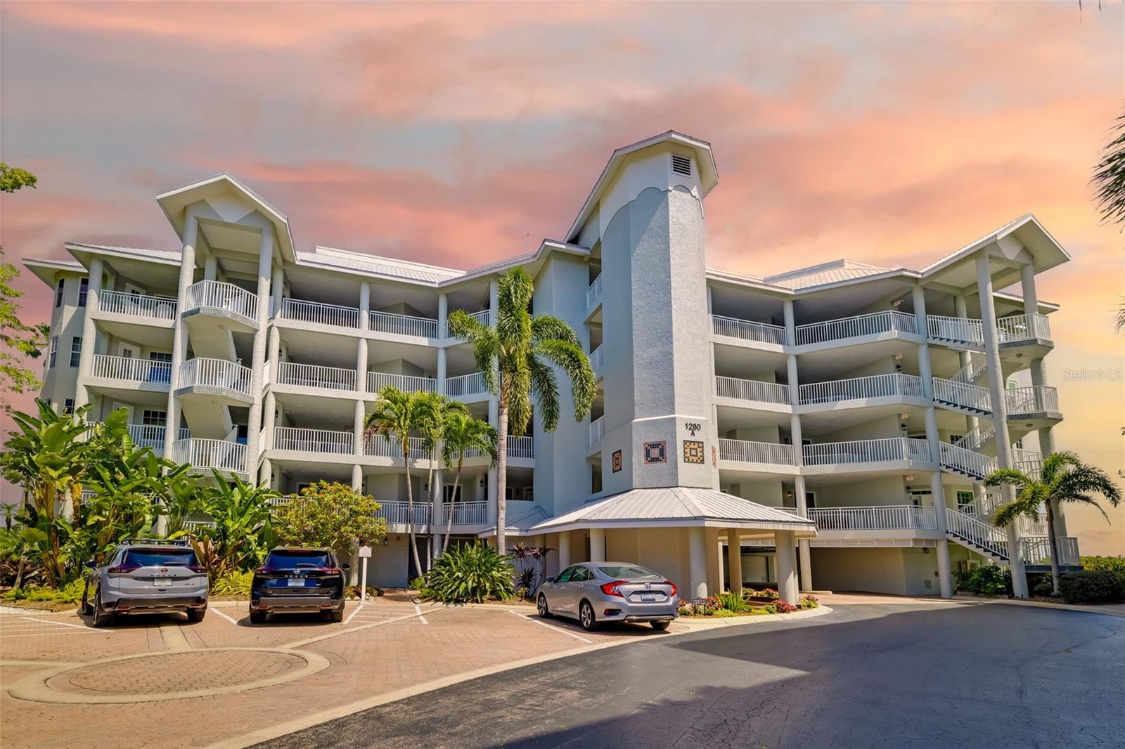 At the pinnacle of an intimate, gated community on world-renowned Siesta Key, this penthouse condominium offers a rare opportunity to enjoy sweeping bayfront living with breathtaking views stretching across the water to the skyline of Sarasota. Offered turnkey furnished, this beautifully maintained residence is ready for immediate enjoyment, whether as a full-time home or a luxurious island retreat. Inside, vaulted ceilings and tile floors enhance the light-filled interior, while plantation shutters add timeless coastal elegance throughout. The thoughtfully designed layout features two bedrooms with walk-in closets and two baths, including an oversized primary suite that provides a spacious and relaxing retreat. Near the dining area is a private den with sleeper sofa for extra guests. The kitchen features white wood cabinets with solid surface countertops and eat-in dining space. A wet bar just off the kitchen can be used as a dedicated coffee station or wine bar. The sunroom extends the living area, inviting you to unwind while enjoying spectacular sunset views over the bay. Go outside to enjoy one of the two covered front patios, ideal for morning coffee or evening breezes. The residence also includes the convenience of a private single-car garage, a desirable feature for island living. With only 50 residences, this gated waterfront community offers a rare sense of privacy and exclusivity. Residents enjoy an exceptional collection of amenities, including a resort-style pool and spa, three desired Har-Tru tennis courts, fitness center and community grilling area, all supporting the vibrant and social lifestyle the community is known for. The day dock and kayak launch provide direct access to the bay for fishing, paddleboarding, kayaking, or simply docking and enjoying the waterfront setting. Experience the best of Siesta Key penthouse living, where panoramic bay views, resort-style amenities and an active waterfront lifestyle come together in one extraordinary residence.