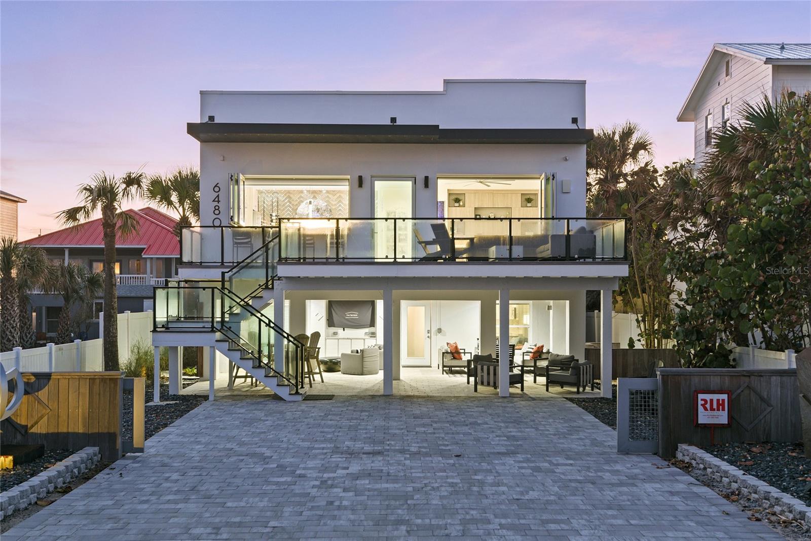 An exclusive oceanfront, gated estate, with a main house and guest home bridge Turtlemound Road to the direct ocean front main house. Completely reimagined by renowned RLH Residential, this transitional design with cool beach vibes is consistent throughout both residences with state-of-the-art function and materials. This pristine location is in the quiet non-driving beach section, Bethune in New Smyrna Beach known for its sleepy old Florida charm we all know and love. Sellers combined two properties, which resulted in a main house oceanside and guest house on Turtlemound across from the intercoastal. Sunsets are captured across the intercoastal and the Florida preserve and coupled with incredible sunrises over the ocean. Best of both worlds can be yours on this special barrier island of Florida. The main-house renovation in 2022 includes a primary second-story suite and living space on second floor with spacious balcony, and two guest bedrooms, living space and kitchenette on ground floor. The owner's second-floor retreat includes a large gathering space with seamless glass slider doors open to second floor deck that allow for panoramic ocean views and blend in the outside. Outdoor living is enhanced with an outdoor fireplace and counter seating from a pass-through window from kitchen, making entertaining a breeze. Designer kitchen includes custom cabinets, Thermador appliances, large center island with seating, dedicated bar and artistic wine wall as the backdrop to a full-sized bar. Electric shades allow for ease of privacy while letting soft translucent light filter into spaces. Beach life is easy with spacious primary, spa-influenced bath, incredible closets and storage. First floor of ocean side home features additional bedrooms and living and leads out to the covered walkout patio, great space to shade from the elements and great for weathering summer rains. A 6-7 car-full paver motor court/driveway is also oceanside, so parking for friends and family is ample on Atlantic-side drive and two-car garage and parking pad on Turtlemound side. The resort-style center courtyard is where all fun happens with a private inground fiberglass low-maintenance pool with water slide. Outdoor shower and bathtub for stargazing and taking in the weather makes Florida desirable. The three-story new construction separate guest house was built in 2023 and rests on Turtlemound Road. The first floor features two-car garage and tons of storage for pool and beach fun. Second and third floors are mini suites, both floors with living spaces, efficiency kitchens and three additional bedrooms in guest house. This six-bedroom 4.5-bath house can accommodate a large family comfortably. These owners have meticulously designed these spaces, and every detail accounted for. This is an incredible opportunity to own an oceanfront estate that has been built and renovated to stand the test of time. Inquire for a detailed list of upgrades of this unique offering and for a private showing.