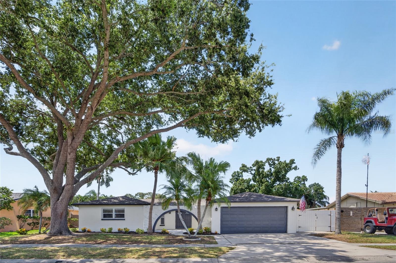 Virtually Staged. Welcome to this beautifully updated 3-bedroom, 2-bath pool home offering approximately 2,030 square feet of living space on an oversized .24-acre lot in desirable Seminole. From the moment you arrive, you'll appreciate the fresh landscaping, mature trees, brand-new pavers, freshly painted interior and exterior, elegant double entry doors, newer windows, a brand-new roof completed in May 2026, and fully paid-off solar panels installed in 2021. Inside, you'll find luxury vinyl plank flooring throughout, updated 5-inch baseboards, recessed lighting, updated switches and outlets, designer interior doors with gold hardware, updated ceiling fans, and an inviting true split floor plan. The spacious main living room features pool views, sliding glass doors, an electric fireplace, and a custom acoustic feature wall. The private primary suite includes custom ClosetMaid organization and a stunning renovated bathroom with floor-to-ceiling tile, quartz countertops, custom cabinetry, gold fixtures, dual rainfall showers with handheld wands, illuminated niches, and a Broan-NuTone ChromaComfort ventilation system with customizable lighting and Bluetooth capability. An oversized laundry room with custom cabinetry, utility sink, washer and dryer is conveniently located near the attached two-car garage. The kitchen offers granite countertops, wood cabinetry, newer Samsung stainless steel appliances, abundant storage, generous prep space, and an oversized island overlooking the screened pool. A secondary living room with a wood-burning fireplace provides additional space for relaxing and entertaining. Two additional bedrooms and a beautifully renovated guest bathroom are located on the opposite side of the home. Outside, enjoy your private backyard oasis featuring a screened pool with safety gate, fully fenced yard, and detached storage shed perfect for pool equipment and additional storage. Major updates include a new HVAC system (June 2026), updated electrical panel, new attic insulation, remodeled bathrooms, permitted garage door replacement, and numerous additional improvements throughout. Move-in ready and thoughtfully updated, this exceptional home offers the perfect blend of comfort, style, functionality, energy efficiency, and Florida outdoor living.