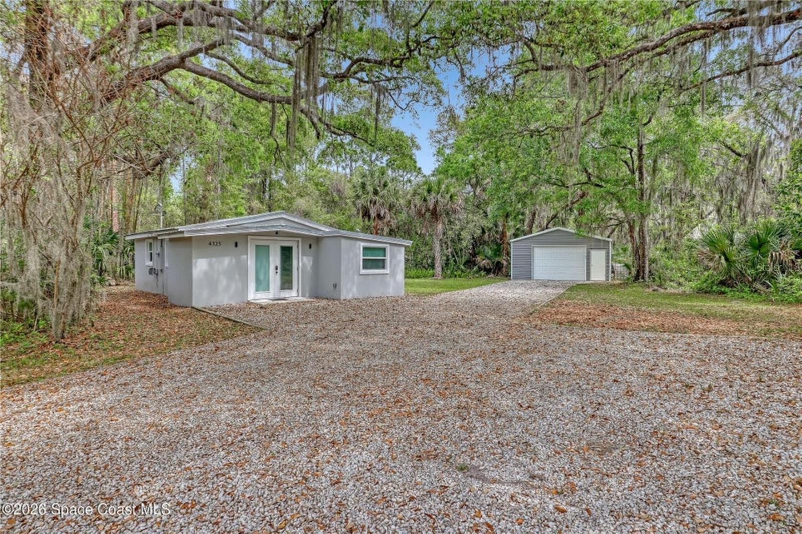 Tucked away on a spacious 1-acre lot in Mims, this delightful home blends cozy living with timeless charm. The inviting living space features beautiful shiplap walls that add texture and character, perfectly complemented by a stylish electric fireplace that creates a cozy focal point for relaxing evenings. Step outside and you'll find plenty of room to enjoy the outdoors. With its combination of modern touches and rustic appeal, this home offers a peaceful escape while still feeling connected and livable. 24x24 detached garage, 20x20 carport and water softener system. Close to the Space Center, I-95 beaches restaurants and more!