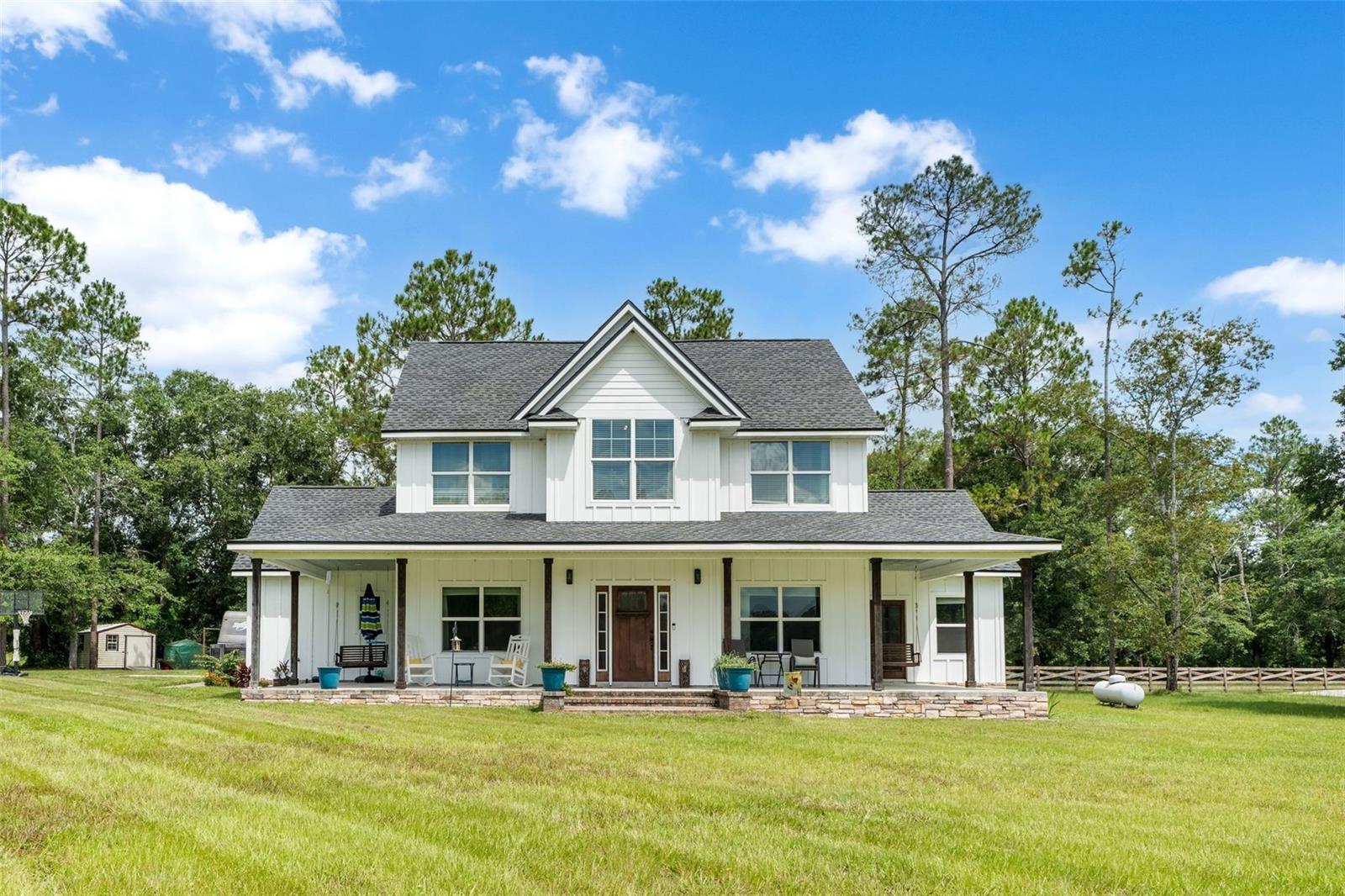 Located just 20 minutes north of Gainesville, this stunning custom home offers the perfect blend of peaceful country living with easy access to city conveniences. Nestled on a beautiful 1-acre lot in the Lake Butler area, you'll love the sense of space, privacy, and charm that surrounds you. Set in Union County, the home is serviced by Clay Electric—not GRU—which means lower utility costs and reliable service, a valuable bonus for homeowners.

Tucked away in a quiet and friendly community known for its small-town feel, proximity to pristine lakes, and outdoor recreation, this thoughtfully designed home offers space, comfort, and timeless style. With 4 bedrooms, 2.5 bathrooms, and a flexible office, there's room for everyone. The chef’s kitchen is a true standout, featuring rich wood shaker cabinets, quartz countertops, stainless steel appliances including a gas stove, and a spacious walk-in pantry. Cozy up by the gas fireplace in the living room or host guests in the formal dining space. Luxury vinyl plank flooring spans the main level, which also includes a mudroom, laundry room, half bath, the luxurious primary suite, and extra storage under the stairs.

Upstairs, you’ll find three more bedrooms, a full bath with dual vanities, and a versatile bonus area ideal for movie nights or play. The primary suite is your private retreat with a spa-like bath that includes a freestanding soaking tub, walk-in shower with double shower heads, dual vanities, and a generous walk-in closet. Modern amenities like Ecobee smart thermostats on both floors and a gas tankless water heater add convenience and energy efficiency.

Step out onto the tiled back porch and enjoy your fully sodded, professionally landscaped, and fenced backyard—perfect for pets, kids, or just relaxing outdoors. The home also features Hardie board siding with cedar beam accents, a charming front porch, side porches with a swing, a 2-car garage, and a whole-home water softener system. Located near the scenic lakes and natural beauty of Lake Butler, this move-in ready home combines peaceful living with high-end comfort—come see it for yourself!