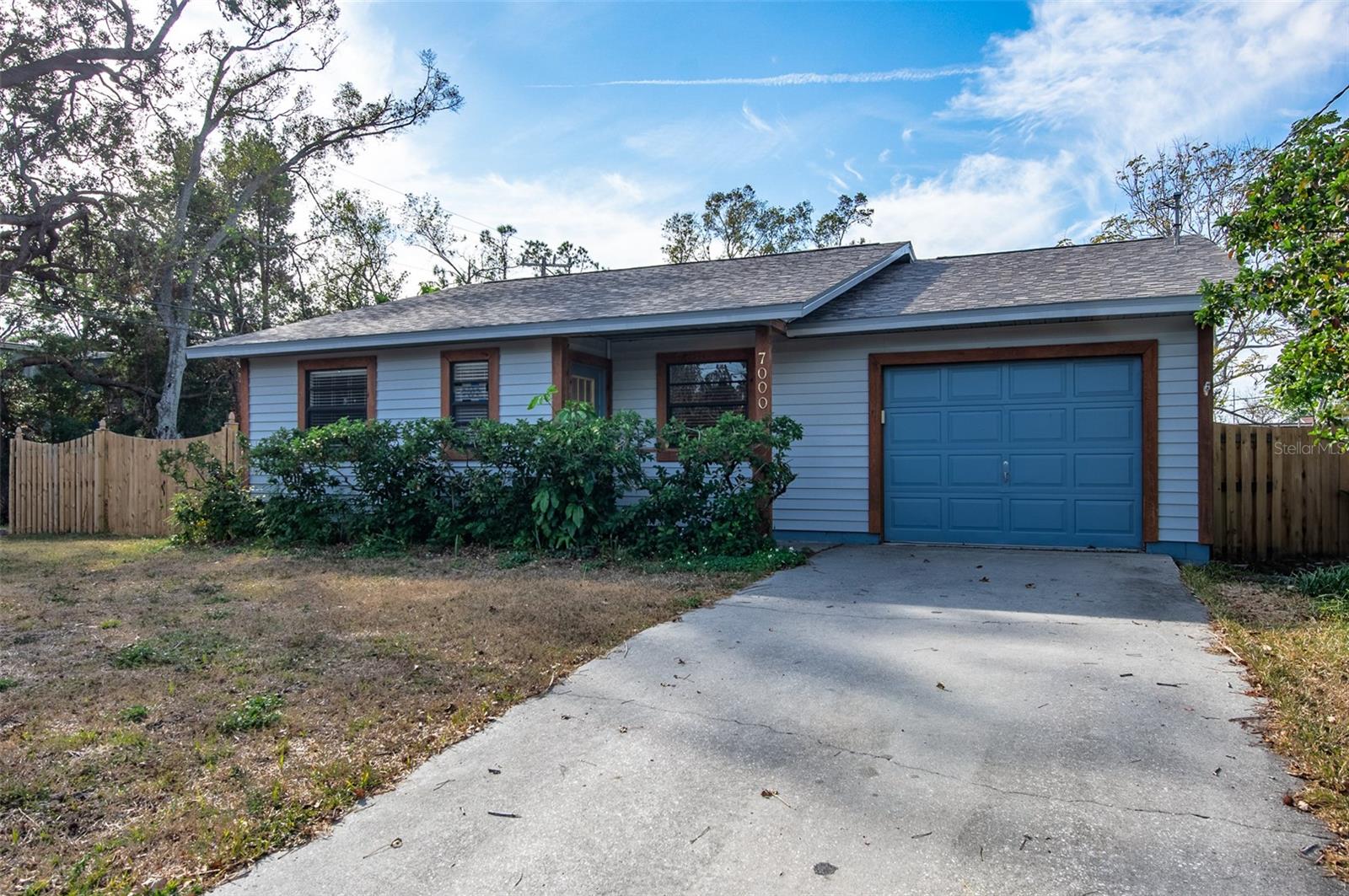 This beautiful, move-in ready 3-bedroom, 2-bathroom home with a 1-car garage is perfectly located in North St. Pete, offering a convenient commute to downtown St. Pete and the greater Tampa metro area. Tucked away on a quiet dead-end corner lot in a safe, non-evacuation no-flood zone, this property offers incredible privacy with only one neighbor to the right. The home perfectly speaks relaxed modern living, welcoming you with ample parking and a covered entry. Inside, a practical split-bedroom floorplan showcases gorgeous, natural organic Saltillo tile flooring throughout the living, dining, and kitchen areas. The main living room features dramatic high vaulted ceilings and opens seamlessly to the kitchen, which boasts clean appliances, a dishwasher, plenty of counter space, and a long kitchen bar that fits a lot of barstools. The entire home is clean, comfortable, and meticulously well taken care of. The spacious master bedroom includes a large walk-in closet and a private ensuite bath, while the in-unit washer and dryer are conveniently located in the garage. Out back, double French doors lead from the living room to an inviting deck inside a fully fenced yard. It is easy to love this home for its secluded end-of-street location, functional layout, pristine condition, open kitchen, and private outdoor space.