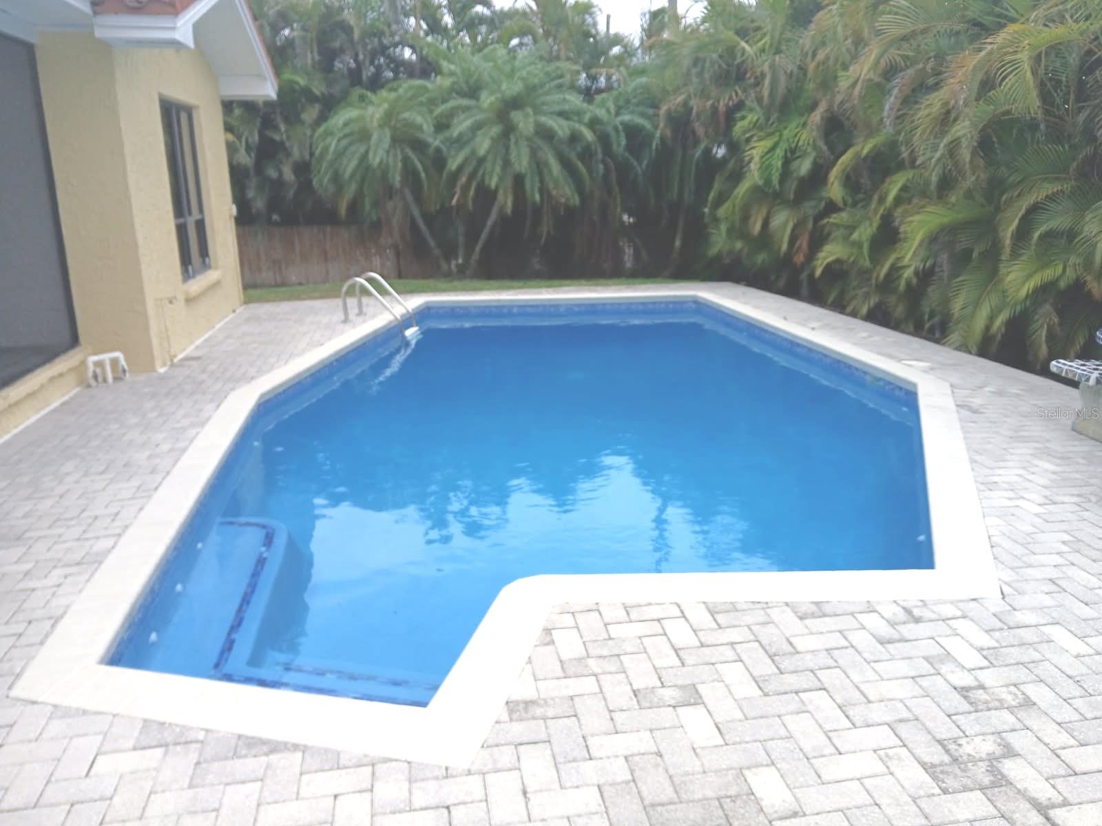Thinking of boating—already own one or looking to buy? You’ll want a place to keep it close by, and this home delivers. Don’t miss this move in ready, beautifully remodeled waterfront 3 bedroom, 2 bathroom home complete with a private dock and 10,000 lb lift. It’s perfect for boaters who want quick, easy access to the water. Spend sunny afternoons lounging by the sparkling pool, and enjoy cozy evenings by the fireplace. Inside, the home feels fresh and refined with new ceramic tile throughout. The kitchen shines with new stainless appliances—range, refrigerator, and dishwasher—making it ideal for gatherings and everyday living in the open floor plan. The 2 car garage with epoxy flooring adds convenience and durability. Thoughtful updates include a new AC, new water heater, new sliding glass doors, new disposal, new kitchen sink, and more. Everything is ready for you—just move in and enjoy effortless waterfront living.