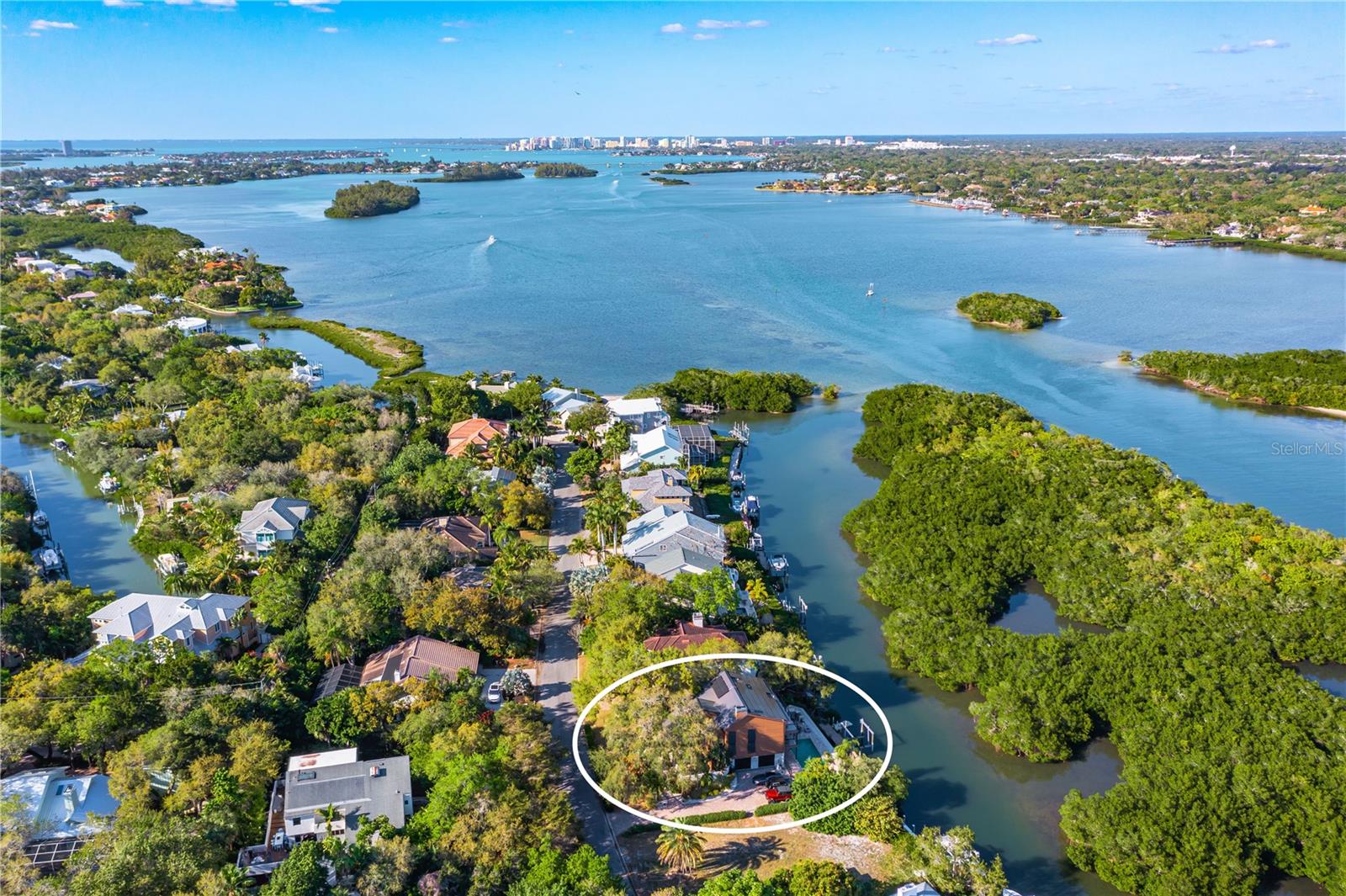 No Hurricane or Flood Damage.  A coastal modern oasis in Siesta Cove, Siesta Key’s premier neighborhood, highlights 80 feet of waterfront with convenient boat access to Gulf and Bay, with newer seawall, boat dockage, and an extraordinary pool that invites you to enjoy Siesta Key’s relaxed lifestyle. Breathtaking Sarasota Bay vistas along the many peaceful panoramic patio terraces provide endless views of nature. On the main floor, a generous kitchen with gas cooktop island opens into the zen fireplace family room and spacious dining room with soaring ceilings and teeming with nature-filled impact windows. Quartz countertops, sleek wood cabinets, and stainless steel appliances for chefs join the jaw-dropping wall of extensive kitchen windows. Additionally, a powder room and spacious guest bedroom complete with en suite bathroom are located on the main level.  Enjoy the top level primary suite, with loft office, secondary laundry room, third large bedroom and en suite bathroom. The lower level features a family room, fourth bedroom, additional laundry room, and a 2 car garage. This modern coastal retreat boasts energy efficient solar panels and is just a short bike ride away from world class Siesta Beach and the Village. Paradise awaits.