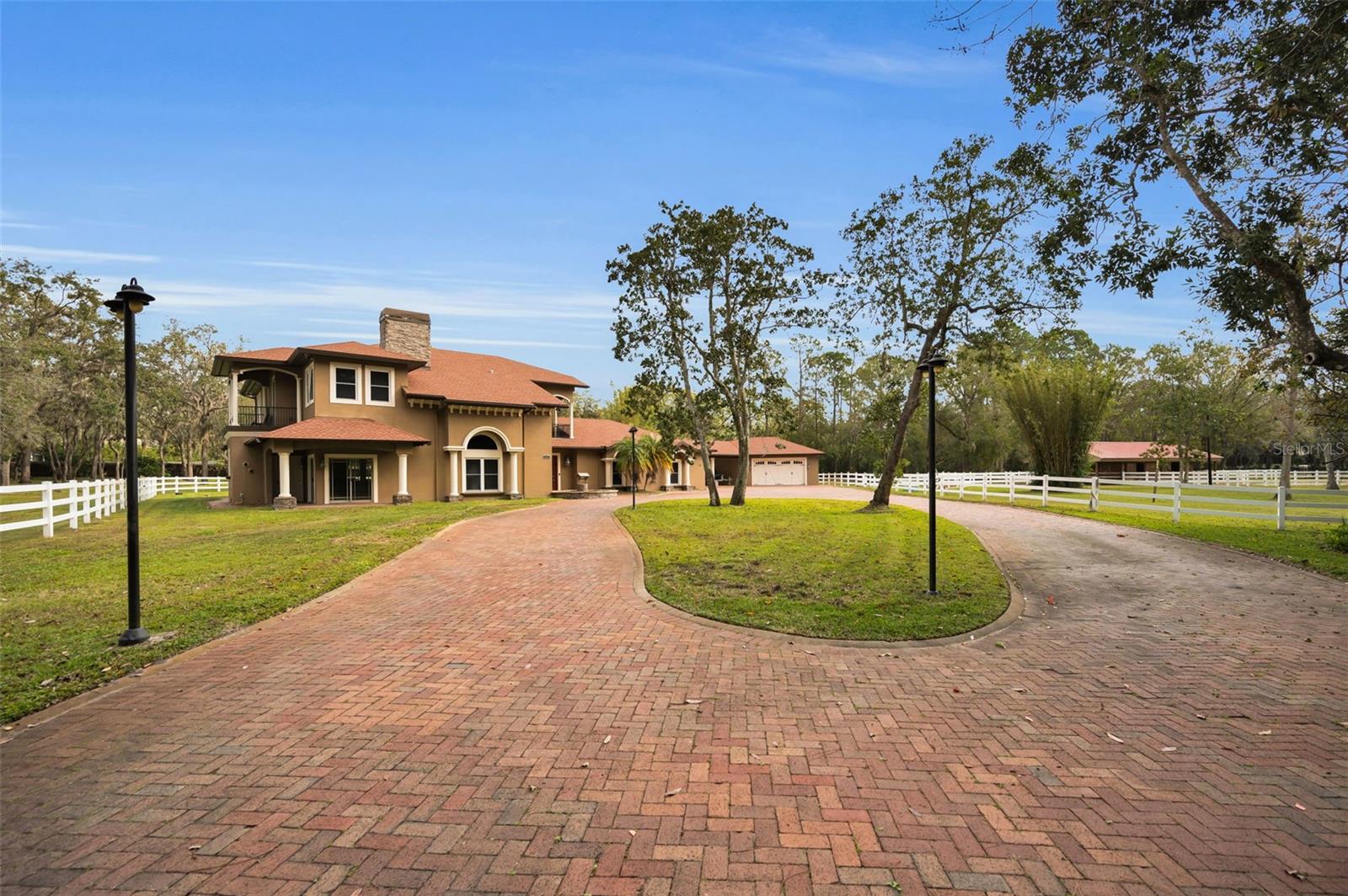 An absolute dream in Oak Hill Acres! Sprawling across 4.4 acres of lush privacy, this equestrian estate offers pure luxury! Located on a fully enclosed and double gated entry corner lot, this stunners offers 4 bedrooms (including 2 master suite options: a master suite downstairs AND a master suite upstairs), 4 full bathrooms, an office, a gym, 2 laundry rooms (1 up and 1 down), saltwater pool & spa, a fully equipped and completely covered outdoor kitchen, a poolside woodburning fireplace, a separate air conditioned safe room space, a gorgeous portico area, a 4 car garage, a beautiful 3 stall barn, a natural pond stocked with bass and an impressive newly built 4 bay RV warehouse! THE GOODS: Roof 2021, A/C’s (3 units) 2019, double pane impact lifetime windows throughout, tankless water heaters (3 units) 2019, new washers/dryers 2019 in both up and downstairs laundry rooms, pool resurfaced 2024, new cartridge pool filter 2024 (sand filter removed), security system 2019, new front gate motor 2019, septic tank pump 2019, 1000 gallon buried propane gas tank, surround sound speaker system both in and out 2019, fresh exterior & interior paint throughout 2019-2020, new flooring throughout 2019-2024, central vac system throughout and dimmer systems on all lighting throughout! THE DETAILS: KITCHEN: The all new chef’s dream kitchen renovation 2019 includes an amazing Dacor gas stove, DCS double oven, impressive SUB ZERO refrigerator/freezer, 2 Bosch dishwashers, wine fridge and ice maker! OUTDOOR KITCHEN: 2020 new built outdoor cover structure/roof 60k. PRIMO 7 burner grill, fridge, sink, icemaker, built in blender, 2 gas burner BBQ, and built in glass gas fire table. BARN: 2018 built 60k, 3 stalls- each with an individual turn out, tack room for all equipment and supplies, wash stall, hot/cold water and electric. Plus multiple fenced in pastures to roam amongst the property. RV GARAGE/WAREHOUSE: 2022 built 80k, 40 X 50 structure, 6 inch concrete floor pad, 4 sets of 16X16 roll up bay doors -awesome! This estate is an absolute oasis! Complete seclusion, yet everything you may need is within minutes! Plus, no deed restrictions -  bring all your Florida toys and zoned agricultural - bring all your animals! A true, rare gem!!!