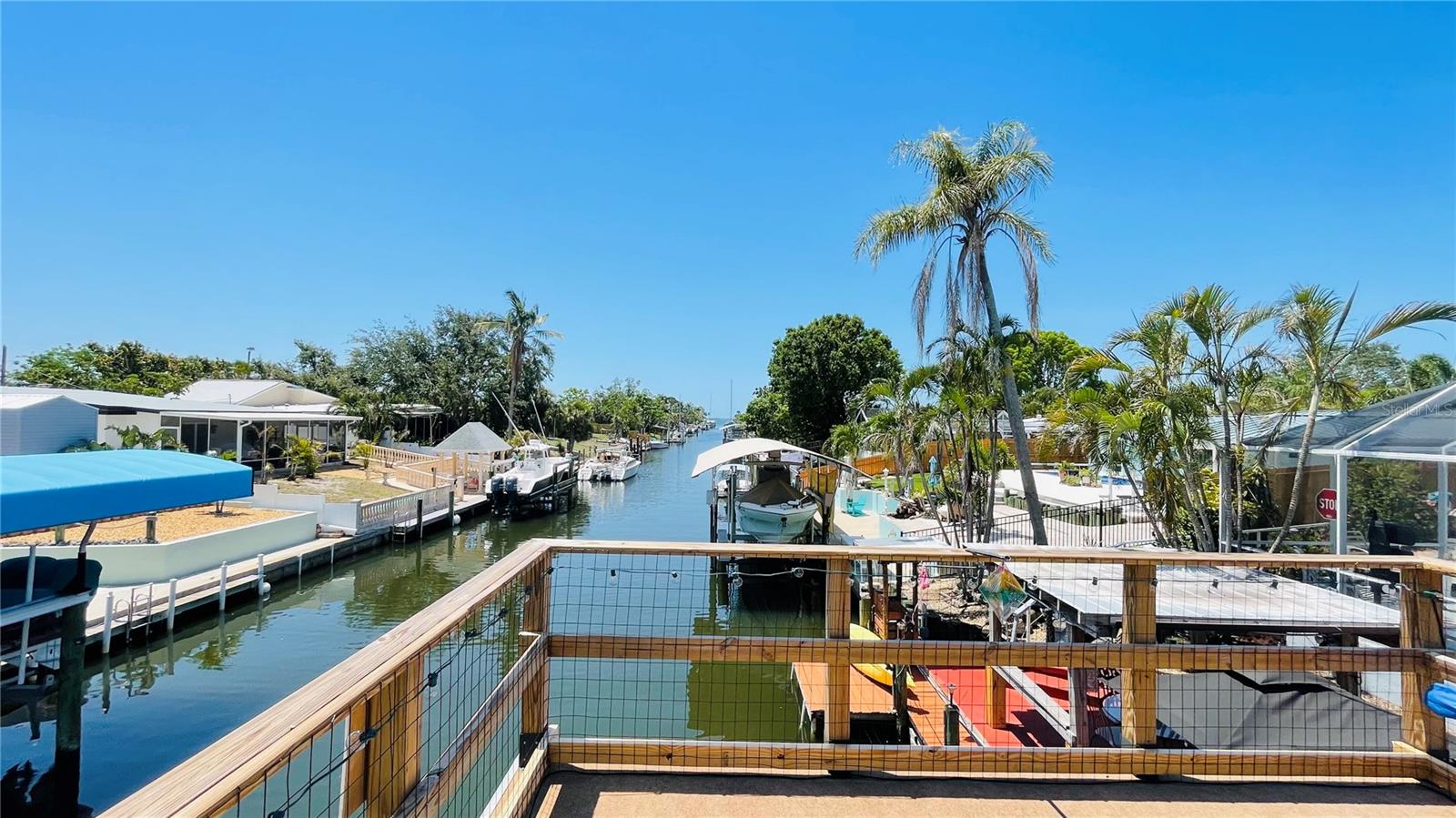 Wake up to sunshine, step outside to waterfront breezes, and launch straight into the boating life from this eclectic canal-front home. Three things you won’t want to miss: 1. HIGH AND DRY, no flood insurance required; 2. SAILBOAT WATER 5 MINUTES FROM SARASOTA BAY; and 3. MARINA and waterfront amenities exclusively available for Bayshore Gardens included in the tax bill! THE HOUSE: Start with the low maintenance no-mow yard and walk through the roughly 1800 square feet of air-conditioned space right out to the enormous covered and screened living area wrapped around the pool. Go down the path to the canal-side tiki bar and boat lift with elevated observation deck offering glimpses of Sarasota Bay. There is so much to love here, accumulated and assembled by the owner of 17 years. SEE ATTACHED OWNER NOTES AND FAQ for details. The boat, a 22-foot, 150 HP Pro-Line cuddy on the lift is included in the sale, along with the outdoor covered Jacuzzi with dedicated water heater. Other furnishings and extensive decorations could be negotiated on a separate bill of sale. The house has stood since the 50s, above the flood plain, and has remained high and dry, season after season. Comfort is the key and the owner has added numerous features for easy living, including a dockside entertaining area with water, power, cable tv, a covered tiki bar, fish cleaning station, and seating area. Atop the boat lift is a permitted, custom 12 x 13 roof and deck with railing for catching views of the bay and islands. There is a lower dock for launching kayaks and loading the boat for the day’s adventures. A short trip down the canal and you are loose on open Sarasota Bay in less than 5 minutes – one of the best bay-access canals anywhere in the area. Other features too -- like extensive landscape lighting, for example -- too numerous to list can be found in the attached documents. Note that the seller is willing to negotiate private financing and will not require flood insurance. This home is located within the Bayshore Gardens Park and Recreational District, with clubhouse, pool, boat ramp and marina (at discounted rates not available to the general public), waterfront park with fishing pier and kayak launch. Boaters and water-lovers hurry, 409 Bryn Mawr Island has it all, all ready for you to start your Florida boating life today!