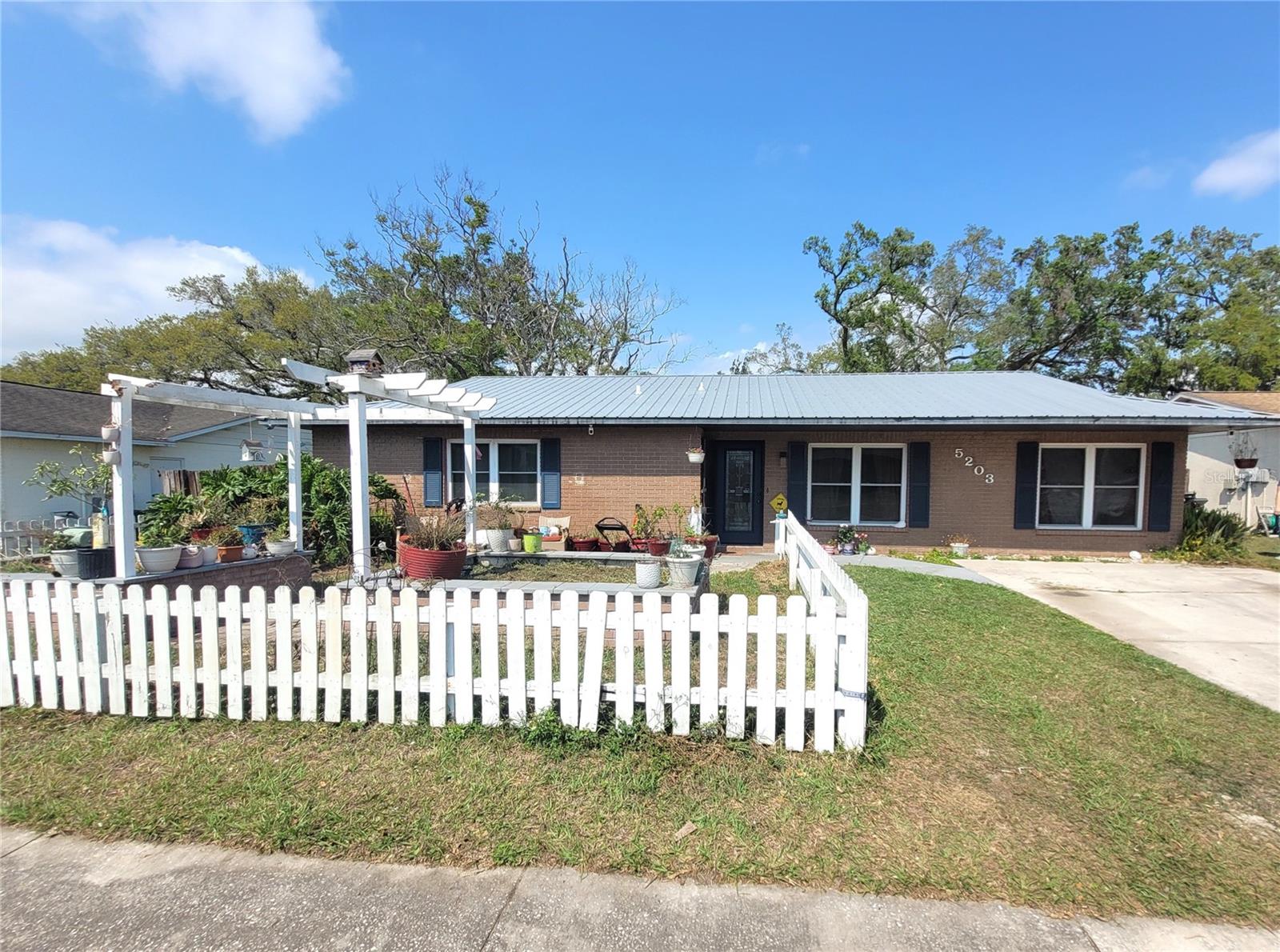 Come home to a quiet, serene retreat in this beautifully maintained 3-bedroom, 2-bathroom residence offering nearly 1,400 square feet of living space in the highly sought-after Presidential Manor neighborhood—known for its welcoming, long-time homeowners. Tucked away toward the back of the community, this home offers added privacy with no HOA and no CDD fees. Owned by only its second owner, it has been thoughtfully cared for throughout the years. A true gardener’s delight, the front yard features concrete raised garden beds framed by a charming white picket fence. The fully fenced backyard provides both privacy and functionality, complete with an electrified shed, pre-wiring for a hot tub, and an expansive screened-in patio with an insulated cover—perfect for staying cool and enjoying Florida living year-round. Inside, the home boasts rich Kempas hardwood flooring throughout the main living areas and kitchen. The kitchen is a standout, featuring custom all-wood cabinetry, a center island, stunning Black Galaxy granite countertops, a skylight, and illuminated glass cabinetry. French doors open seamlessly to the screened patio, creating an ideal indoor-outdoor flow. Two bedrooms are comfortably carpeted, while the primary suite features laminate flooring and a private en-suite bathroom with tile finishes. Major upgrades include a lifetime metal roof installed in 2017, brand-new air conditioning system, and double-pane hurricane-impact windows throughout the home for added efficiency and peace of mind. Conveniently located just minutes from major interstates, this home offers easy access to dining, shopping, and everyday essentials—including Walmart, Winn-Dixie, Publix, and Aldi—all within a short drive. Nearby nature parks add even more to love about this exceptional location. This move-in-ready home combines comfort, charm, and convenience—and it won’t last long!