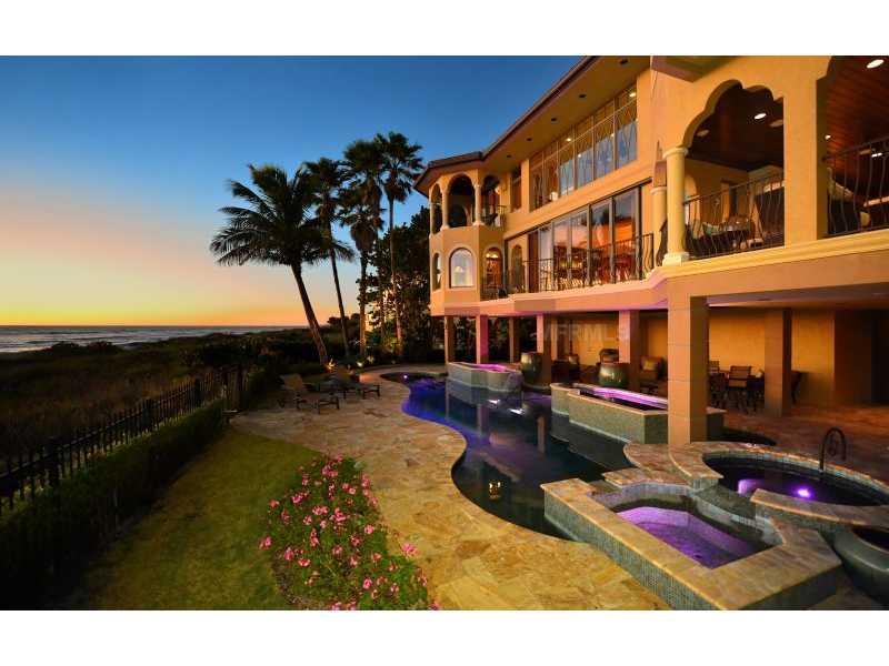Pristine luxury awaits in this custom-built six bedroom plus office home situated on the white-powdery shores of Longboat Key's Gulf front. Professional landscape welcomes you with tropical foliage and lush, manicured surroundings; featuring tranquil fountains and a Lilly pond in the serene courtyard. Beautiful stone and hardwood floors lead to the expansive living room, with glass walls to showcase panoramic views of turquoise Gulf waters. A few steps away is the impeccable chef's kitchen, butler's pantry with built-in Miele coffee maker, formal dining room, and a temperature-controlled, secure wine cellar. The living room also shares a double-sided gas fireplace that leads out to the recessed gulf front portico. This unique, air-conditioned outdoor entertaining area features a fully-equipped summer kitchen with stainless steel appliances and is the perfect place to enjoy Gulf breezes as you entertain guests or simply while the day away. The second level is complete with spacious guest suites, a second laundry room and a private sitting room with morning kitchen and wine cooler. The master suite is a wonderful haven in virtual privacy. There is an office with custom built-ins, walls of glass and a secluded roof top terrace to enjoy far-reaching Gulf sunsets. The lagoon-inspired lanai is the perfect finishing touch to this impressive home. Tumbled Travertine deck, heated pool and spa, wading pools, custom lighting and water features, plus a full bath with a private outdoor shower.