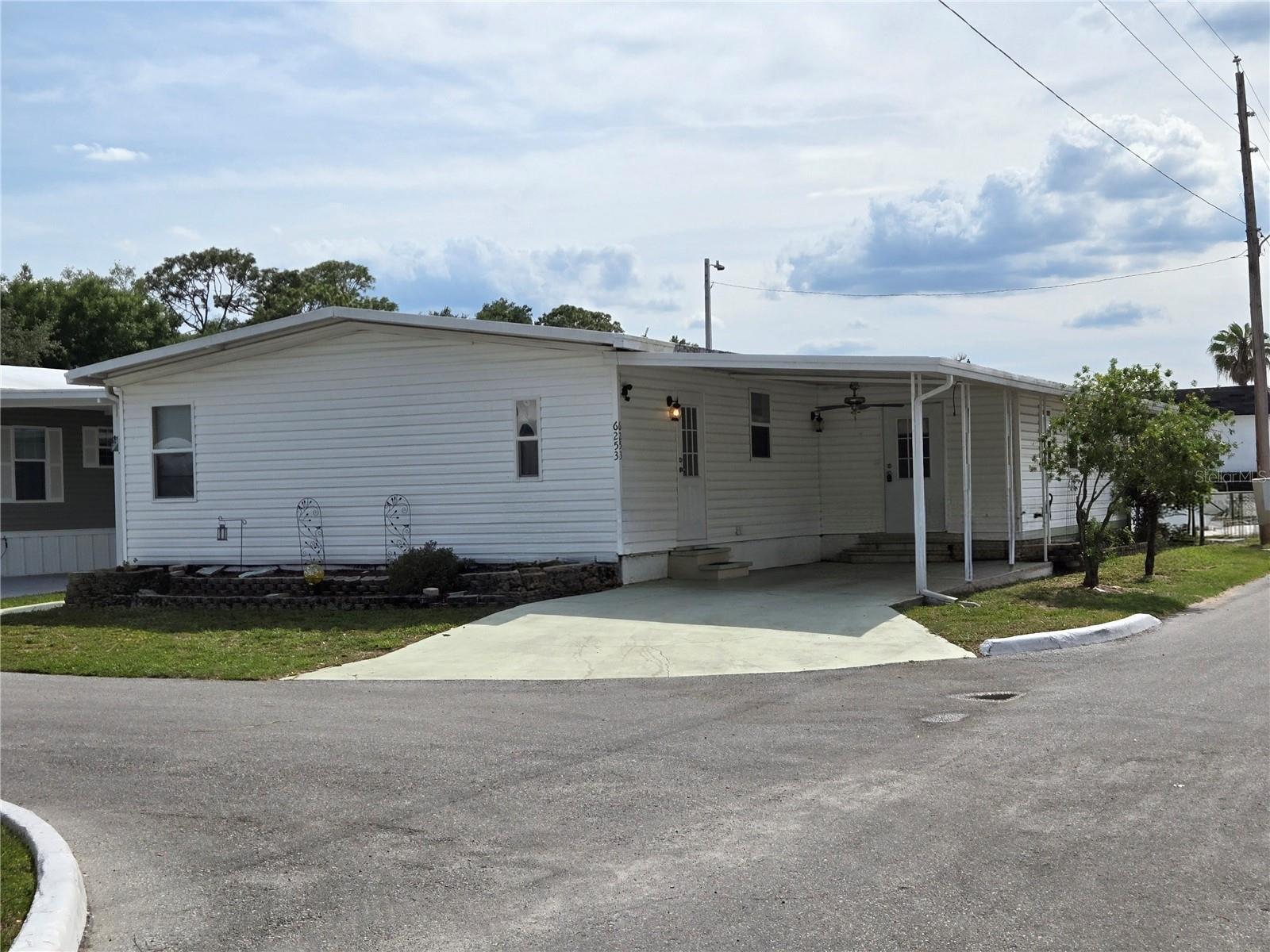 Wecome to County Aire Village 55+ Community with Ownership and LOW HOA (140.00 monthly) includes internet, cable, water, sewer, and amenaties.  Florida living at its best with an Active Living community. Enjoy concerts at the 5 Acre lot on the week-ends. This Double Wide boast space with LARGE rooms. You enter the home off the carport to the Bonus room which is open to the Combo Dining room/Living Room. The floor plan has a split bedroom set up. The Bedroom in the rear of the home has its own ensuite bathroom with a Huge soaking tub and shower as well as a walk in closet. Through the dining room is the kitchen with a quaint breakfast nook for two. Lots of cabinets and two pantry's for plenty of storage. Just down the hall on the left is a nice LARGE Laundry Room with washer and dryer, upper cabinets, and a storage closet. Across the hall is a HUGE 20 x 15 bedroom with 2 double closets for ample storage. The second bath is across the hall with a walk in shower and an additional linen closet at the end of the hall. The A/C was replaced in 2020 and the home plumbing has been changed out to PEX. The Metal roof is a 50 Year and was serviced and sealed 2025. This home is located right near the pool and recreation hall. The Parking lot behind the home is perfect for guest and the back door opens to the parking lot. So much to love about this location and floor plan.