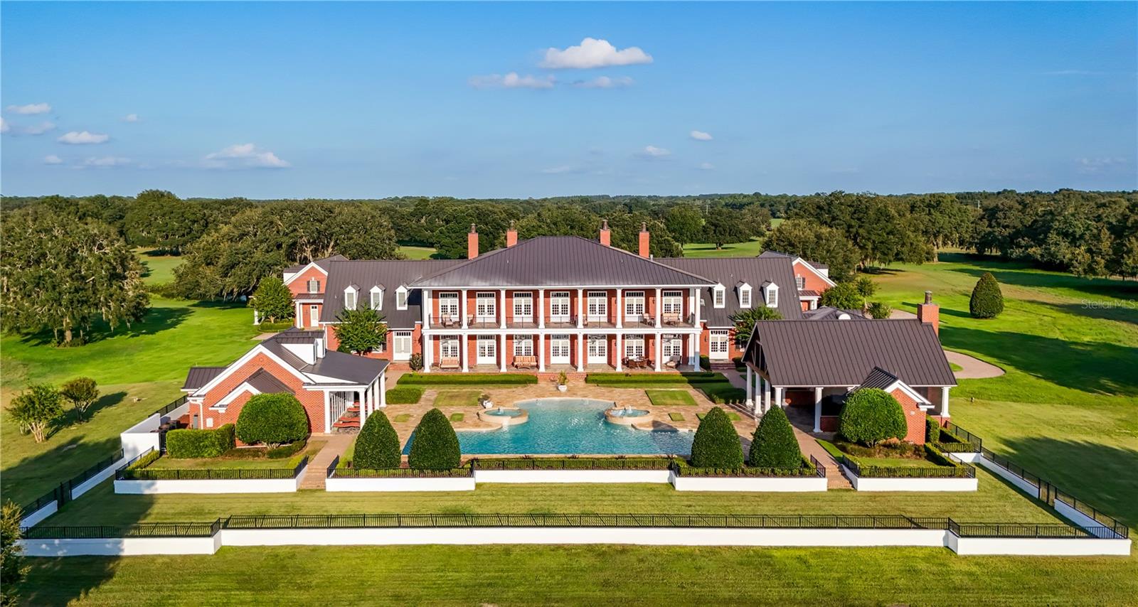 !!! HUGE PRICE REDUCTION !!!! Grandiose and serene 50 acres Estate, meticulously maintained, in Marion County, close to Mount Dora, the Villages, many Lakes, Leesburg, and the Ocala National Forest. Only 1h from Orlando International Airport.
Designed in the purest European tradition with a perfectly symmetrical architecture, concrete blocks from bottom to roof, a Mansion with an impressive foyer, elevator, elegant dining room, impressive kitchen, cosy family room with gas fire place, library, movie theater, office, safe room, 3 half bathrooms and on the second floor, master suite, ensuite bedroom, flex room that could be a 3rd bedroom, extensive laundry and a half bathrooms, 2 covered patios. 
There is a remarkable resort style pool, fountain, jacuzzi, a dining pavilion with kitchen, a wellness center with bathrooms, sauna and gym.
For your guests, a lovely and spacious house with 3 ensuite Bedrooms, laundry, Kitchen open to the Dining / Living room.
A spacious 5 cars garage with workshop, full bathroom, dog wash and storage in the 2nd floor. 
A barn shop for the agricultural equipment, in the back of the property, with a climate control room, a full bathroom and a generator.
Outside: Mature trees, dog run, 3 shooting ranges (25ft for pistols, 200 and 400 yards for rifles and long guns), Multiple water birds and grey cranes by the 2 ponds stocked with fishes.
Also 2 commercial generators (2 weeks autonomy), dehumidifiers, Creston system and more. No Zone restriction.
Amazing opportunity to take over this legacy. An estate for generations. 
No Zone restriction. Watch the video on YouTube. It's UNIQUE!