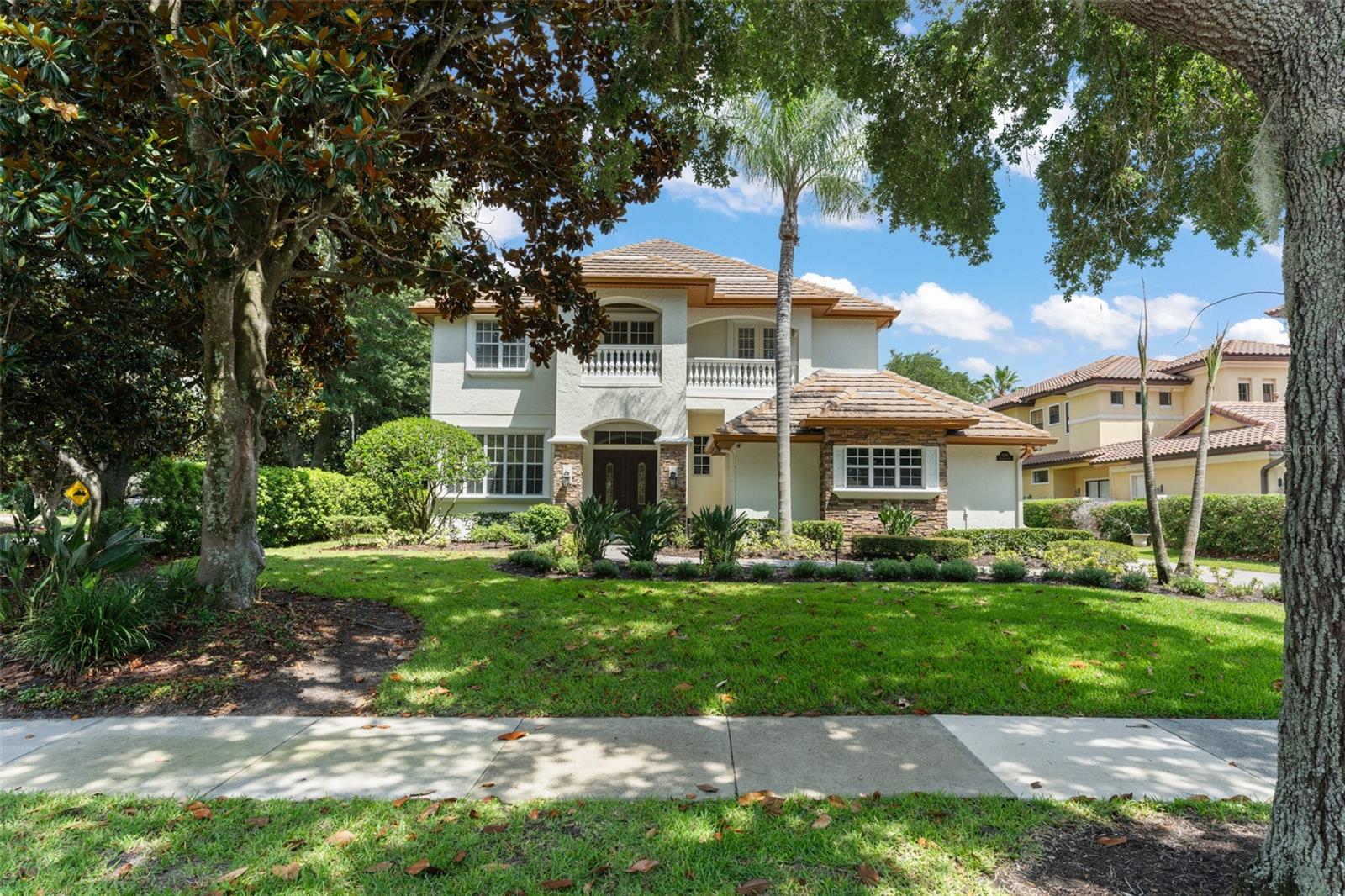 Positioned on a corner homesite along the 18th hole of the Golden Bear Club within the guard-gated community of Keene's Pointe, this thoughtfully updated custom home offers five bedrooms, four full bathrooms, and three half bathrooms, combining exceptional golf-front living with breathtaking views of the golf course, pool, and surrounding landscape. A grand foyer welcomes guests with a soaring 22-foot ceiling, while oversized tile flooring extends throughout the first floor. Expansive windows fill the home with natural light while creating a seamless connection to the outdoor living spaces.

The well-designed floor plan features a dedicated office with a coffered ceiling, spacious living and dining areas, and a beautifully appointed kitchen with beautiful cabinetry, granite countertops, a professional-grade gas range, center island, and abundant storage. Just off the kitchen and family room is a spectacular custom entertainment bar featuring extensive cabinetry, generous serving space, and four under-counter refrigerators, creating the ultimate setting for entertaining.

The first-floor primary suite serves as a private retreat with direct access to the lanai and pool area. The updated spa-inspired bath features designer cabinetry, quartz countertops, a freestanding soaking tub, oversized walk-in shower, premium fixtures, and elegant floor-to-ceiling tilework. Completing the owner's retreat are two spacious walk-in closets, including a large walk-in closet directly off the bedroom and an additional oversized walk-in closet conveniently located off the bathroom, providing exceptional storage and organization.
The secondary bedroom layout offers both comfort and privacy for family and guests. Two bedrooms feature en-suite bathrooms, while two additional bedrooms are connected by a Jack-and-Jill bathroom. The expansive second-floor bonus room serves as a versatile gathering space, ideal as a media room, game room, lounge, or secondary family room. A dramatic vaulted tongue-and-groove wood ceiling creates architectural interest and warmth, while large windows and French doors fill the space with natural light and provide direct access to the covered second-floor terrace overlooking the pool and golf course. A conveniently located half bath serves the bonus room and outdoor terrace, making the space perfectly suited for entertaining family and guests.

Designed to embrace Florida's indoor-outdoor lifestyle, the home offers an abundance of covered outdoor living space. The resort-style outdoor area features a covered lanai, summer kitchen, pool, spa, dedicated pool bath, and multiple gathering spaces thoughtfully positioned to capture views of the Golden Bear Club's signature finishing hole.

An expansive covered second-floor terrace with a tongue-and-groove wood ceiling is accessible from multiple bedrooms as well as the bonus room, providing stunning views of the pool and golf course. A spiral staircase leads to a private third-story observation deck featuring a wet bar and panoramic views across the fairways and surrounding treetops, creating the perfect setting for entertaining, enjoying evening sunsets, or watching play unfold along the Golden Bear Club's signature finishing hole.