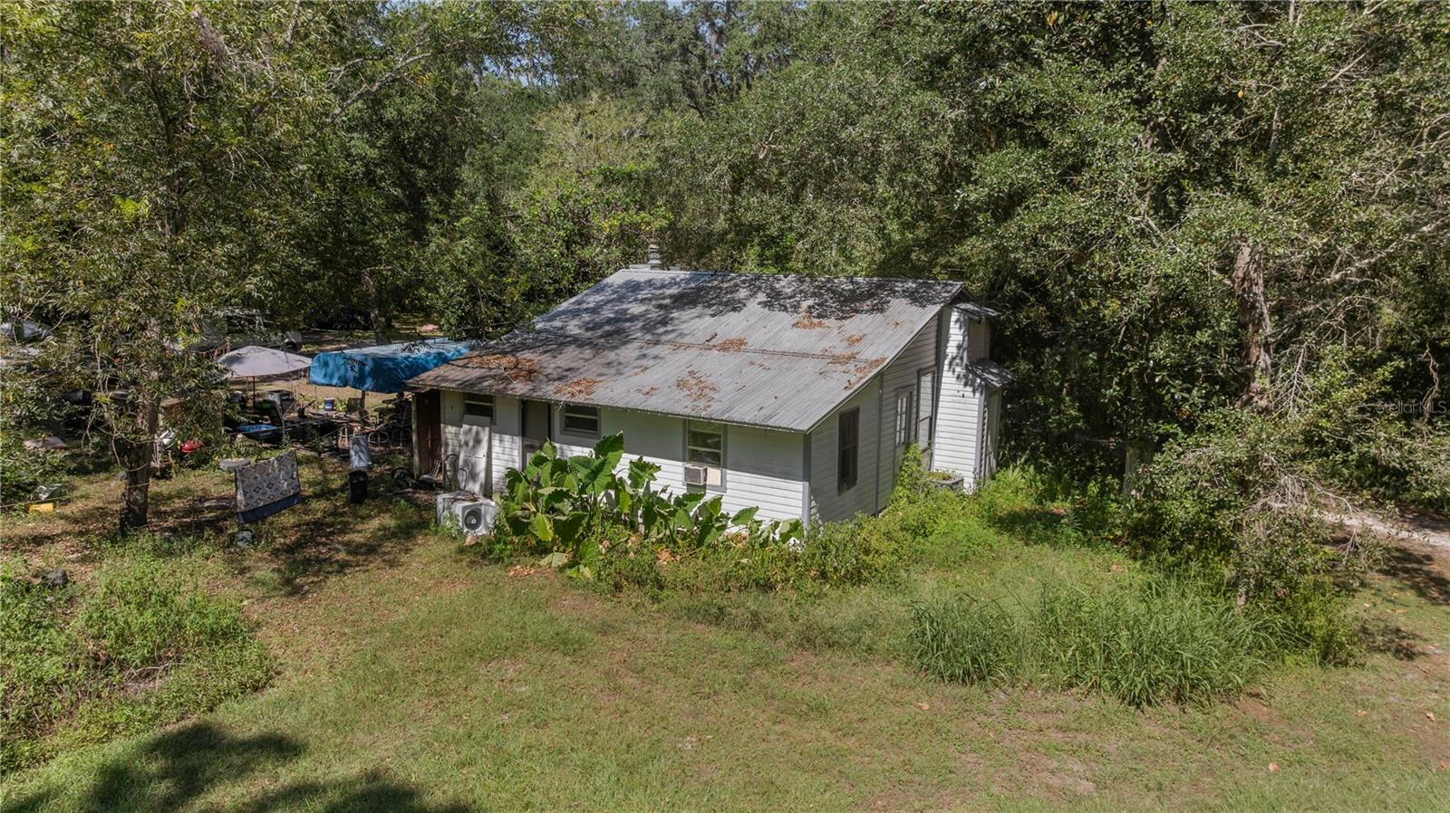 Location is the key to this exceptional development opportunity on SW 34th Street, Gainesville. Majestic Oak trees create a stunning canopy over this beautiful parcel, offering the timeless charm and scenery of Old Florida. This rare offering presents the opportunity to develop a gorgeous private estate or create a cluster of habitat-supportive residential homes on approximately 14 acres located along the historic Rocky Point Road portion of SW 34th Street. GRU has confirmed that both water and sewer connections are readily available. The property currently includes three older frame homes that are considered to have no contributory value, as the true value lies in the land itself, whether for future development or as a private residential retreat. Once part of a large cattle operation, this property offers rich history, beautiful natural surroundings, and incredible potential. Additional acreage may also be available, as this parcel represents the northern portion of a larger 39- acre tract. Ideally located with convenient access to I-75, US 441, Shopping, restaurants, and everyday amenities, this is a truly unique opportunity in one of Gainesville's most desirable growth corridors.
