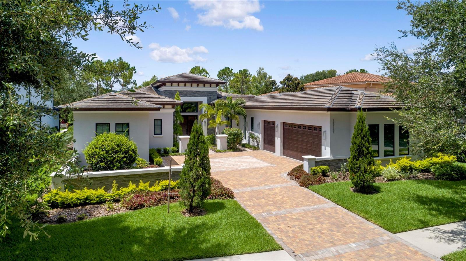 This transitional single-story home, custom built in 2021, offers an open floor plan built for both entertainment and comfortable living. This four-bedroom, four-bathroom residence provides more than 3,300 square feet of interior living space and features an incredible, private outdoor living area with an infinity-edge pool.

White polished porcelain floors stretch throughout the main living areas of the home including the foyer, formal dining area, family room and kitchen. The kitchen displays high-performance appliances by Bosch and Sub-Zero, an elegant coffee bar with wine storage, walk-in pantry, black quartz countertops and a grand center island that adjoins the kitchen and family room.

Floor-to-ceiling sliding glass doors lead from the family room to the large outdoor living area. A stone paver deck extends off the back exterior of the home, connecting the covered lanai with a summer kitchen, sparkling pool with raised spa and sophisticated landscaping overlooking tranquil water views.

The owner’s suite, occupying the back left-wing of the home, has direct access to the lanai and fire pit through a private rear entrance. The luxurious owner’s bathroom showcases a glass, double rain shower, two separated spacious vanities that frame a free-standing tub and a generous walk-in closet with ample built-in storage.

Additional features include: Spacious laundry room; Designated office; Three-car garage.