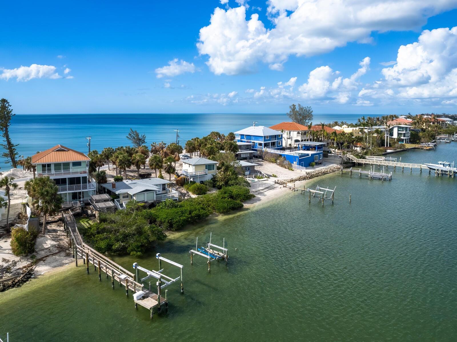 One or more photo(s) has been virtually staged. Welcome to Casey Key, your personal paradise! This home offers unparalleled waterfront living with views that stretch across the Gulf of America and Little Sarasota Bay. From the great room and elevated primary suite, you can enjoy sunrise vistas over the tranquil bay and breathtaking sunsets over the gulf. The design of this home is an ideal blend of coastal simplicity and charm, with aluminum railings that seamlessly connect the interior with expansive outdoor spaces. Key features include hurricane rated impact windows and doors, metal roof, full home generator, elevator, dock and 12,000 lb lift.  Whether you're looking to relax, entertain or indulge in your love for boating, this property has it all. The deep-water dock offers direct access to the bay, making it an ideal spot for boating enthusiasts. Plus, with an eight-mile stretch of pristine beach right at your doorstep, you’ll have endless opportunities for beach visits, sunbathing or enjoying the serene sounds of the water. Offered as-is with right to inspect, this property is a rare opportunity to own a one-of-a-kind residence on one of Florida’s desired barrier islands. Don't miss the chance to make this incredible waterfront home your own.