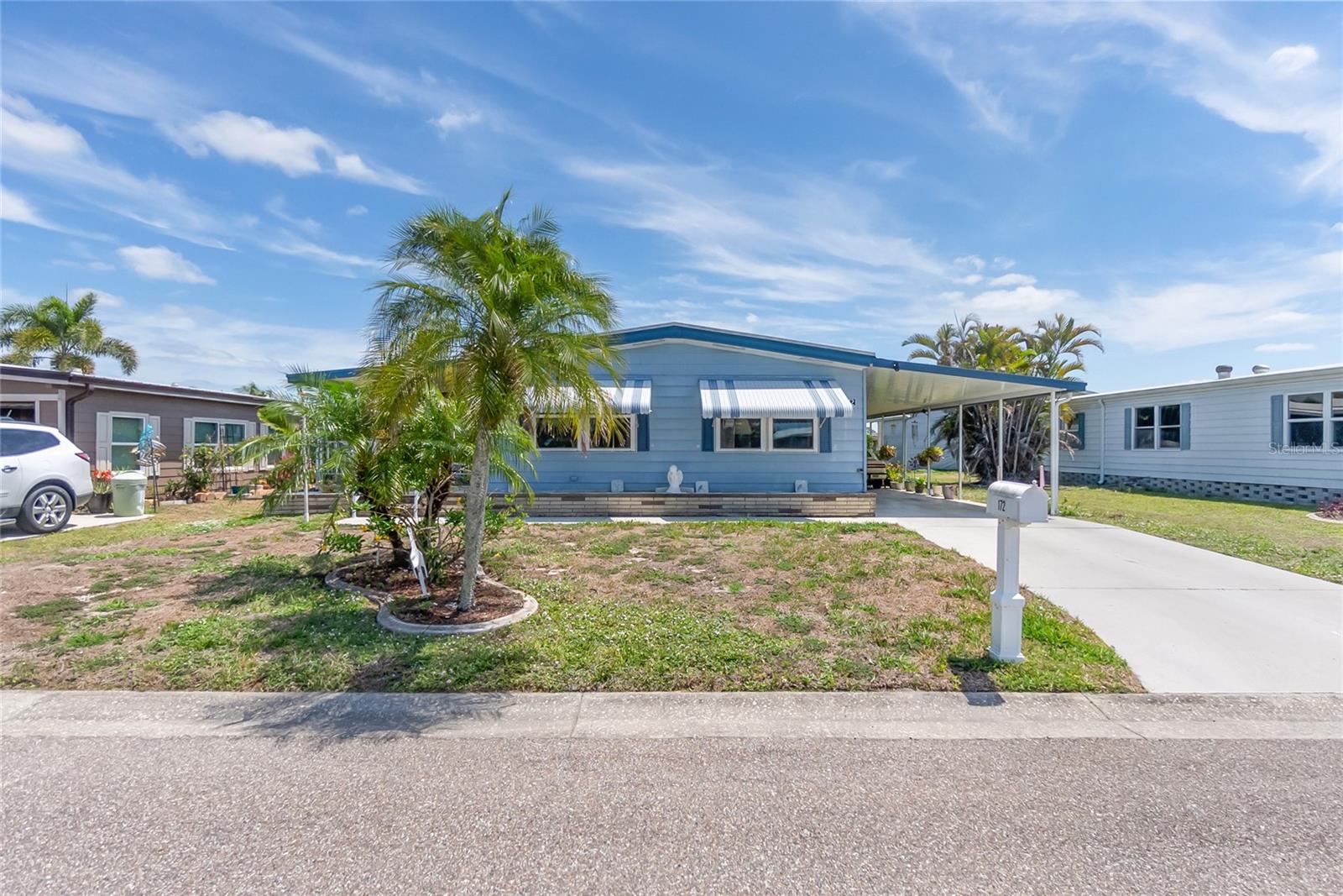 Ready to take it easy? Grab your pole and your bocce ball. This leisure-packed, 55+ Gated Community is waiting for you! With thoughtful amenities like a large community pool, spa, sauna, pickle ball, tennis, bocce ball, lawn bowling, horseshoe pit, dog park, shuffleboard, library, billiards, and more, you will never struggle to find your lane. Learn a new skill at the hobby/recreation rooms, go fishing in Snook Lake, slip your boat in at the community marina, or work on your golf game at the golf practice nets. Veterans enjoy support and friendship at regular meetings. And your home? What's not to love? Almost new roof, new windows, almost new stove and microwave. 2023 water heater, updated drywall, updated doors and trim, built-in dinette cabinetry, custom-built kitchen island, spacious lanai, covered front porch, clean landscaping, carport, storage, and more. Don't wait for the good life, it's right here!