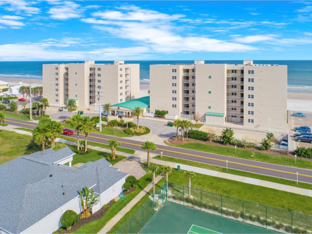 Virtually Staged. This awesome completely renovated direct oceanfront 2 bedroom / 2 bath residence offers an inviting open concept floor plan boasting stunning views of the azure Atlantic ocean and the pristine ''no drive'' sugar sand beach in Ponce Inlet! Walk out your sliding glass doors and relax on your private oceanfront patio on the same level as the manicured grounds. This condo feel like an oceanfront private home! Enjoy the convenience of main level living with no elevators, stairs or hallways to navigate. This luxurious condo has many upscale features including porcelain tile plank flooring throughout, upgraded baseboards, remote control window shade on living room sliding doors, recessed lighting & a large private oceanfront patio with tile flooring. The chef's remodeled and expanded fully-equipped kitchen features stainless steel appliances, soft close wood cabinetry, granite countertops, breakfast bar, wine fridge and ample storage space. The spacious oceanfront primary suite has a luxurious updated bathroom with a rejuvenating steam shower, dual sinks and granite countertops. A large inside laundry room adjacent to the primary bath is ideally located and has a full-size stackable washer & dryer included and plenty of space for storage. A huge guest bedroom accommodates two queen size beds which are included and a sizable closet with organizers. The guest bathroom is also beautifully updated! New hot water heater in 2025 & new exterior HVAC in 2021. Enjoy resort-style amenities include a sparkling heated oceanfront pool, large oceanfront club room with kitchen, pickleball, tennis, shuffleboard & basketball court. Expert management with no pending assessments. Pet friendly with two pets allowed and NO weight limit. Centrally located near the iconic Ponce Inlet Lighthouse, Lighthouse Point Jetty Park, marinas, world-class charter fishing, waterfront dining, fresh seafood markets, dog park and beach, and more. Just 30 minutes to Daytona International Airport and approximately 90 minutes to Orlando International Airport. Orlando's world-class theme parks are between 1.5 to 2 hours drive. A truly rare opportunity to embrace Florida coastal living at its finest!