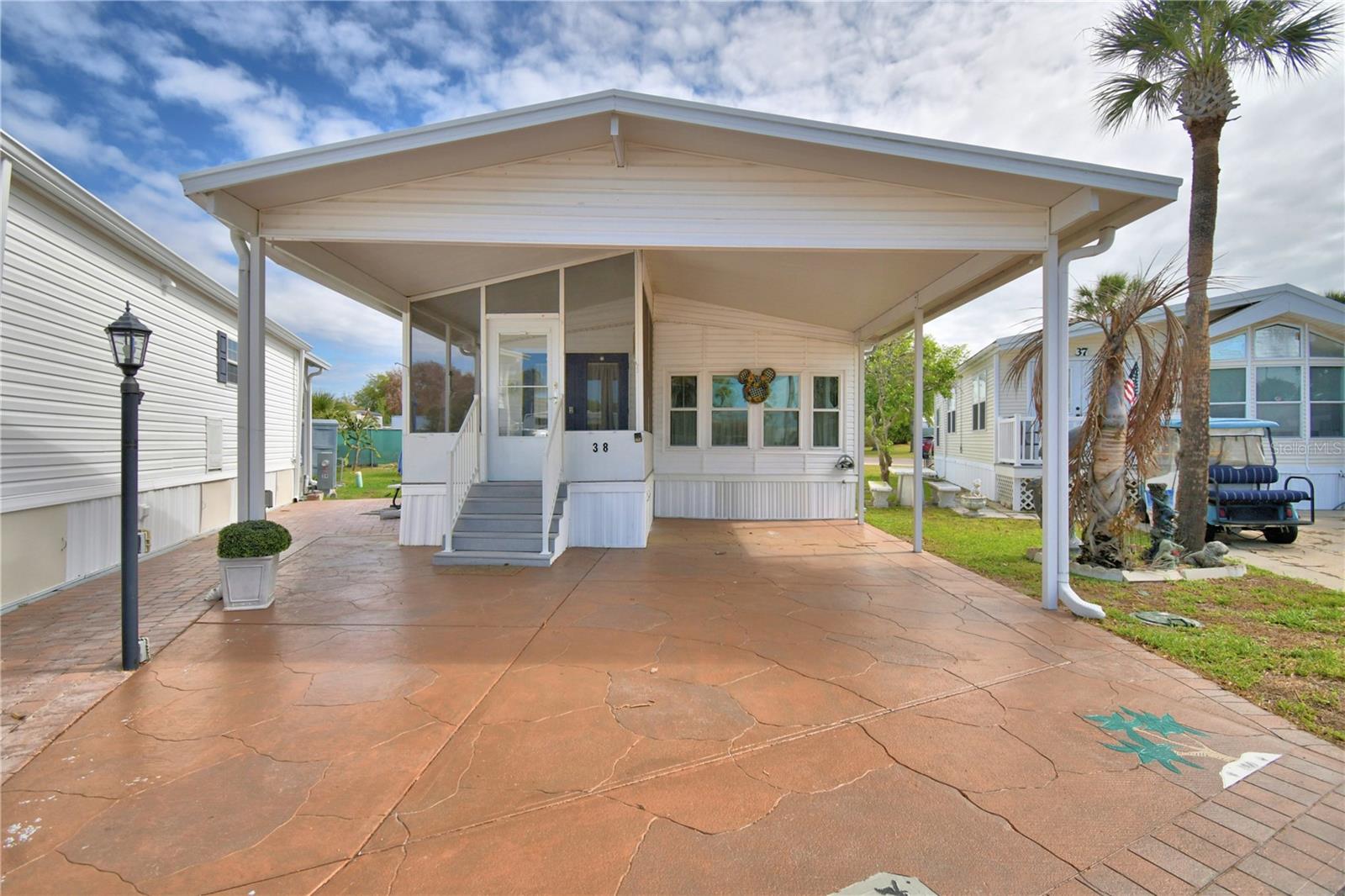 WELCOME to OUTDOOR RESORTS at Orlando, a premiere 55+ Community (Four Corners area) located 6 miles west of Walt Disney World on the shores of Old Lake Davenport in Polk County, Florida. This community offers a 24-hour Gate Shack and an amazing amount of amenities to enjoy including 2 Community heated Pools, Tennis Courts, 9 hole golf, Clubhouse, Dog Park, Boat ramp on Lake and fishing  and so much more. Own your land and Lot#38 features a covered carport with pavers, screened front porch which leads you into an open concept beautifully FURNISHED home with a spacious living room, a separate dining area and kitchen with bright cabinets and appliances. Split bedrooms, upgraded bathroom with walk-in shower and laundry room combo. Home has many upgrades: Roof (membrane) 2023, thermal pane windows 2020, vinyl siding replaced, newer stackable W/D 2024, sink filter, hot water heater 2024 and laminate flooring throughout home was installed. Newer insulated Shed for your additional storage needs. HOA paid quarterly includes: Water, Sewer, Cable, Trash, Lawn care, 24 hour security and resort-style amenities. FLORIDA LIFESTYLE AT IT'S BEST. Centrally located near Shopping, Dining, Medical and major roadways to our East/West Beaches or Orlando to Tampa for travel and entertainment. Call today for your showing appointment.