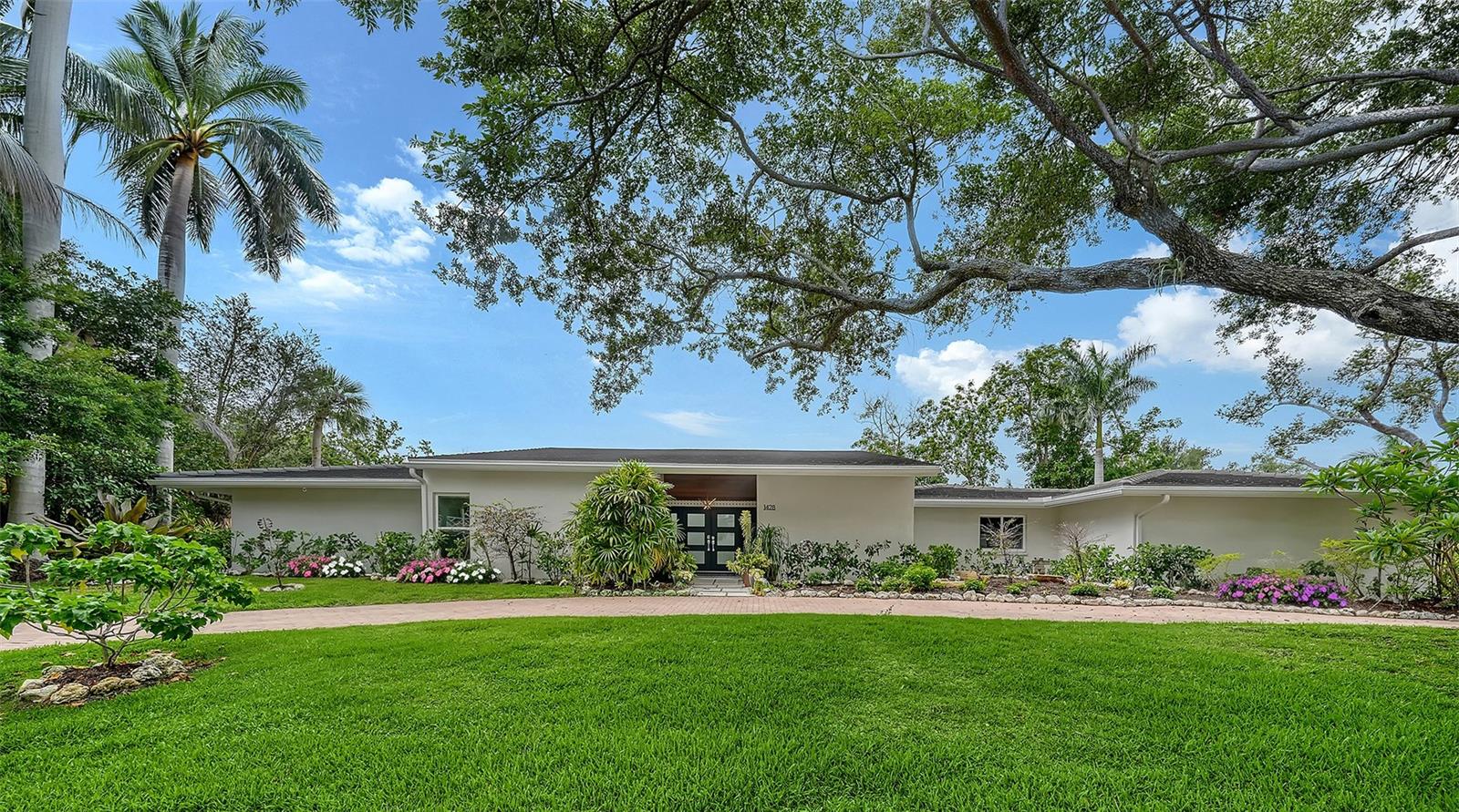 A rare opportunity within the coveted West of Trail enclave of Pine Bay, this beautifully renovated residence is nestled on a quiet dead-end street near the historic Field Club and offers the perfect blend of privacy, sophistication, and convenience.  Designed for effortless Florida living, this 4-bedroom, 3.5-bath home is filled with natural light, soaring vaulted ceilings, clerestory windows, and dramatic walls of glass. Twelve sets of sliding doors blur the line between indoors and out, wrapping around a stunning screened courtyard with a heated pool and spa to create a private resort-like setting rarely found at this price point. The thoughtfully redesigned interior showcases quartz countertops, custom cabinetry, designer finishes, induction cooking, rich engineered hardwood flooring, custom built-ins, and integrated smart home technology. Every space has been curated for both comfortable daily living and elegant entertaining. Outside, mature tropical landscaping surrounds the renovated pool and spa, featuring new tile, resurfacing, 2026 pump, expanded deck areas, upgraded drainage, landscape lighting, irrigation, and a remote-controlled privacy screen, creating an extraordinary outdoor retreat for gatherings, relaxation, or movie nights under the stars.  Peace of mind comes with substantial recent improvements including 2020 renovated kitchen and baths, 2020 tile roof on the main residence, Miami/Dade hurricane-rated glass and doors, 2024 Kohler whole house generator, Savant smart home system with electric blinds, whole house Puronics water purification system, seamless gutters with gutter guards, updated electrical panel, and a 3 car garage with an air conditioned bay.  Just minutes from Siesta Key Beach, Downtown Sarasota, Southside Village, Sarasota Memorial Hospital, and world class dining, shopping, and cultural attractions, this exceptional West of Trail residence delivers the privacy of a hidden enclave with the convenience of Sarasota’s most desirable destinations at your doorstep.