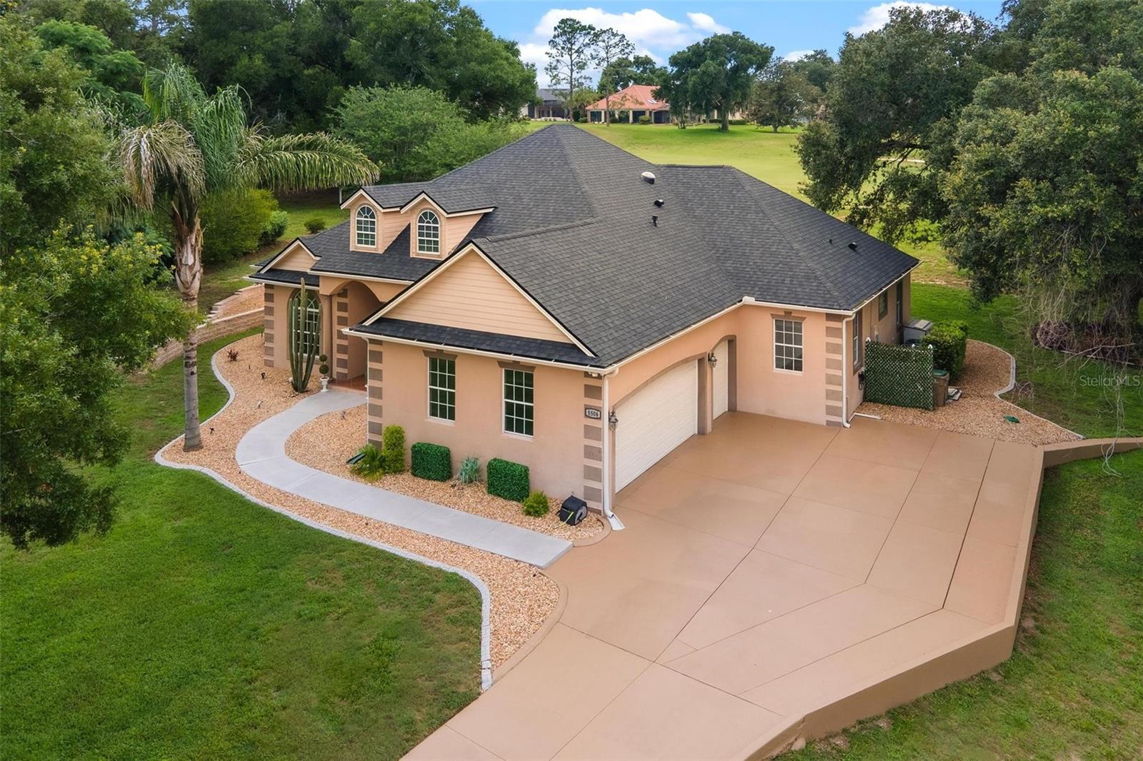 DREAM HOME ALERT located in an all age, 24/7 Guard-Gated Golf Community! Tucked away on a quiet cul-de-sac, this half-acre is situated on GOLF FRONTAGE (15th Green). This beautifully designed home offers the perfect blend of comfort, elegance, and unforgettable entertaining. The open-concept floor plan features a chef-inspired kitchen with granite countertops, a huge island with wine refrigerator, gas cooktop, double convection ovens, walk-in pantry, and snack bar seating for up to nine guests! The spacious dinette area could also serve as a combo family room features a built-in desk or Bar area. The luxurious primary suite with a decorative electric wall fireplace, is a private retreat with French doors to the pool, spa-like bath, and dual custom walk-in closets. Oversized bedrooms 2 & 3 share a remodeled bath with a jetted tub. Working from home is a delight in your own private Den/Office! Step outside and fall in love with your own backyard paradise! Enjoy the sparkling pool and an incredible CUSTOM SUMMER KITCHEN complete with a built-in grill, smooth cooktop, dishwasher, sink, and granite countertops—perfect for hosting family and friends year-round. Patio furniture and gas firepit convey!! Surrounded by majestic oak trees with no rear neighbors, you'll enjoy the privacy and tranquility you've been searching for. Homes like this rarely become available. Don't wait—schedule your private showing today before someone else is living your dream!