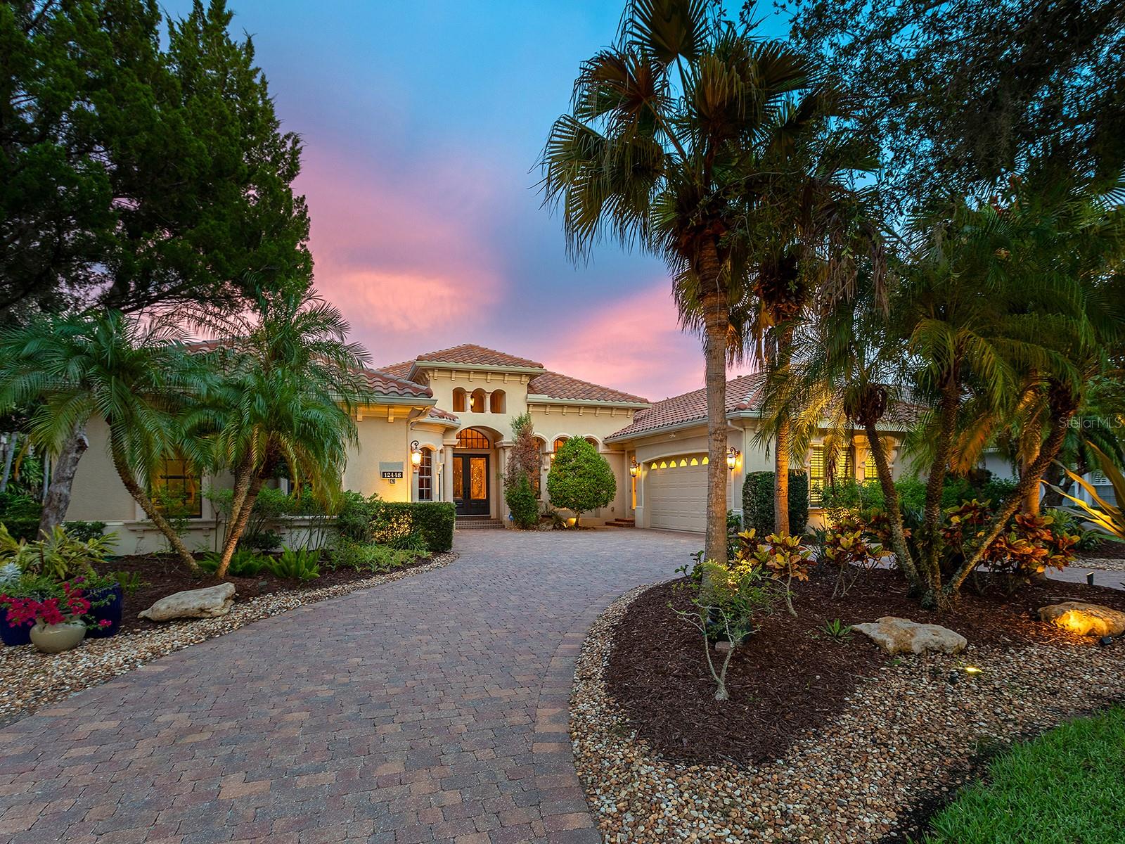 Nestled amidst 0.46 acres of lush conservation is this meticulous former Lee Wetherington model home adorned with opulent upgrades and custom elements in every room.  Located in the upscale Highfield neighborhood within Lakewood Ranch Country Club is this Addison model; offering an inviting yet spacious residence with over 4,700 SF for every member and lifestyle, including formal and casual living and dining spaces, upgraded kitchen, two separate office spaces, second-level bonus room retreat, luxurious primary bedroom suite, and 3 additional guest bedrooms, 2 guest bathrooms plus 2 powder baths.  You are welcomed home to this magnificent residence with a large circular paver driveway and a split 4-car garage with each bay having direct access to the home.  The foyer opens from double glass doors and showcases the floor-to-ceiling detailed and custom elements you’ll find throughout this residence – custom ceilings with beams and coffers, architectural columns, custom painted walls, solid core doors, and a warm welcoming color palette.  The formal living room highlights the garden-like lanai and conservation with a large aquarium window, custom coffered ceiling, and stone-surround gas fireplace.  Enjoy your meals in the formal dining room with tented ceiling and custom wine bar featuring glass display cabinetry, bar fridge, and wine bottle shelving.  The carefully designed kitchen offers custom cabinetry with spice racks, display cabinets, cookbook shelves, pot and pan drawers, and gorgeous moldings, plus a central island with prep sink.  Enjoy upgraded appliances from the gas cooktop with pot filler, dual dishwashers which are great for entertaining and large dinners, and paneled refrigerator.  Casual meals are a delight from the breakfast bar or the dinette with aquarium window.  The family room embraces the Florida lifestyle of seamless indoor and outdoor entertaining with disappearing corner sliding glass doors to the lanai with a cozy fireplace, dining area, full outdoor kitchen, wood ceilings, and windows overlooking the preserve.  Surrounded by verdant gardens, the gas heated saltwater pool and spa is the ideal place to cool off or sunbathe on the sunshelf.  When it’s time to work you have the choice of two expertly outfitted studies, both equipped with custom bookshelves and built-in desks.  The primary suite with wood floors is bathed in natural light from the large windows and sliders with serene conservation views.  The spa-like bathroom spaciously offers privacy for owners with dual walk-in closets in the hall, split vanities, soaking tub with whirlpool, walk-in shower, and a private courtyard with outdoor shower.  Guests will find comfort in 3 guest bedrooms, large enough for a king bed, plus a jack & jill bathroom, and a dual function pool and full bathroom.  The second level is the ideal space for fun with a large bonus room that has plenty of space for games, billiards, movie zone, play room, fitness area, teen retreat and more, and you’ll never want to leave with a private balcony, powder bath, and dry bar.  Appreciate a state-of-the-art fitness center, clubhouses, junior Olympic-sized pool, four 18-hole championship golf courses, tennis and pickleball, and more by becoming a member of the Lakewood Ranch Country Club. Lakewood Ranch is the top multi-generational community in the country for 7 years in a row with award-winning shopping, dining, A-rated schools, parks, and nearby beaches.