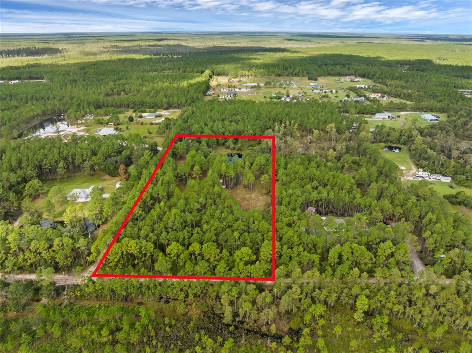 **Price Improvement** Discover your private slice of paradise at 60 Natalies Lane in Ormond Beach! This stunning 5-acre wooded property offers the perfect blend of seclusion and convenience—featuring a serene private lake, power already on-site, well water, and RV hookups. Whether you're planning to build your dream home, set up a weekend retreat, or enjoy as-is, the possibilities are endless.
The property includes a shed, a greenhouse structure, and there's no HOA to restrict your vision. With a septic system being the only missing utility, you're nearly ready to go. Quiet, natural surroundings just a short drive to town amenities and beaches—don’t miss this rare opportunity to own a unique piece of Florida land!