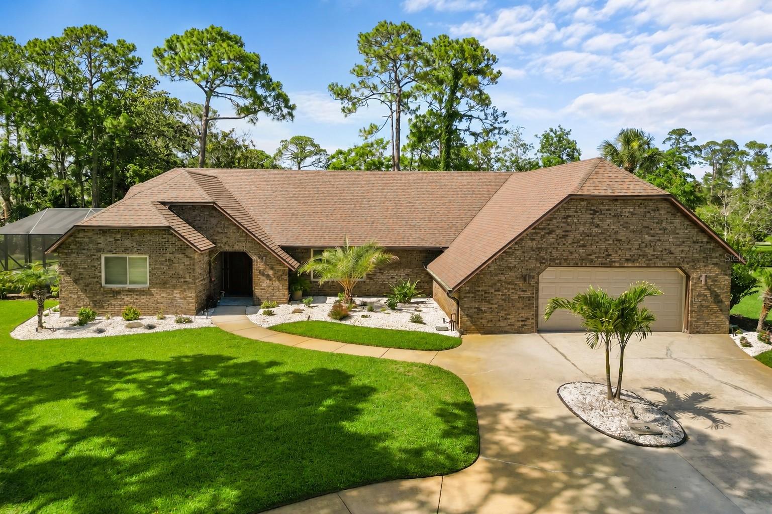 Welcome to 112 Peachtree Circle, a beautifully maintained brick pool home situated on an oversized lot beneath mature trees in one of the most desirable sections of Indigo Lakes without the burden of an HOA.

Offering nearly 2,700 square feet of living space, this thoughtfully designed 3-bedroom, 2.5-bath home combines spacious living, privacy, and exceptional indoor-outdoor entertaining. Step inside to soaring ceilings, abundant natural light, and an open-concept floor plan that creates an inviting atmosphere for both everyday living and hosting guests.

One of the home's most unique features is its private guest wing. Tucked behind a pocket door, two secondary bedrooms and a full bath are secluded from the main living areas and served by their own HVAC system, creating the perfect guest wing, multigenerational living space, or private retreat for family and visitors. One of the bedrooms features sliding glass doors with direct access to the lanai and pool area, offering guests their own seamless connection to the outdoor oasis.

The spacious primary suite offers a peaceful escape, complete with a sitting area ideal for enjoying your morning coffee or unwinding at the end of the day.

Outside, Florida living takes center stage. Relax in the brand-new saltwater pool installed in 2022, soak in the heated jetted plunge pool on the lanai, and enjoy the beautifully screened outdoor living space featuring a new pool cage and screened lanai completed in 2022. Whether entertaining a crowd or enjoying a quiet evening at home, this backyard oasis feels like your own private slice of paradise.

Recent updates include a new roof (2023), pool heater (2023), two HVAC systems (2017), luxury vinyl plank flooring, updated kitchen countertops, backsplash, sink and faucet, refreshed bathrooms, Ring security features, and a Tesla wall charger installed in 2022. The professionally enhanced landscaping is accented by brass-cased uplighting installed in 2024, offering both white and multicolor lighting options that create a stunning ambiance after sunset.

Additional highlights include generous attic storage and a location that offers the best of both worlds, just minutes from shopping, dining, medical facilities, and everyday conveniences while maintaining the peaceful feel of an established, tree-lined neighborhood.

Homes offering this combination of character, privacy, updates, outdoor living, and the rare opportunity to enjoy Indigo Lakes without an HOA rarely become available. Come experience everything 112 Peachtree Circle has to offer.