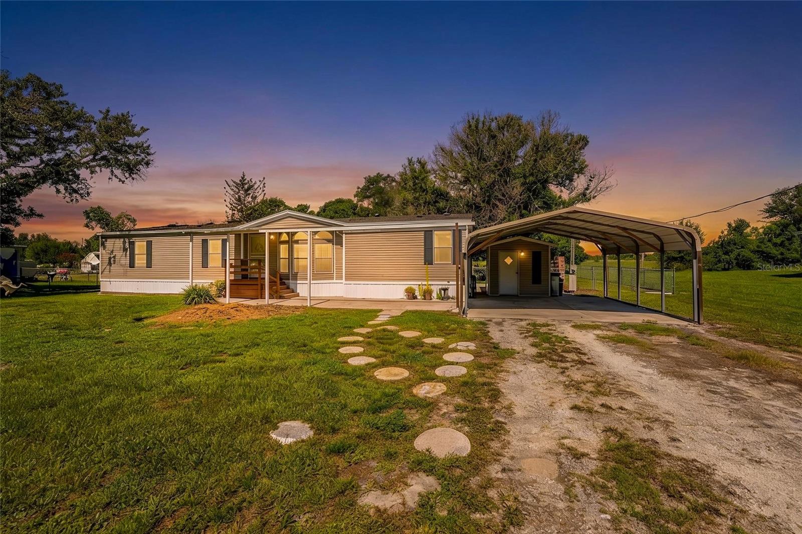 Welcome to this spacious, move-in ready 3 bedroom, 2 bathroom manufactured home, perfectly situated on a half-acre in Arcadia, Florida.
Offering 1,629 SF of living area and a desirable split bedroom floor plan, the heart of this home is the bright and cheery living room, dining area and kitchen, filled with natural light and equipped with a pantry, white cabinetry and appliances, an island perfect for meal prep, and plenty of counter space. 
The primary bedroom offers wood laminate flooring and views of the backyard, making it a peaceful retreat with its en-suite bathroom featuring a walk-in shower with glass doors, a garden tub, double vanity, and a large pass-thru closet. 
Two guest bedrooms also feature walk-in closets and wood laminate flooring, making them ideal for family, guests, or a dedicated work-from-home or hobby room. 
The guest bathroom has a single vanity and shower/tub combo, and sits across the hall from the Laundry Room. 
Just outside the kitchen, you step onto the covered rear porch (with ceiling fan) and down into the screened patio. 
The fully fenced .5 acre yard- partially shaded by mature oak trees- gives you the yard you’ve been needing to grow your own garden, store your work equipment, or simply enjoy the privacy. 
A 15x21 metal storage building serves as a great workshop, with lighting and electrical is ready for your tools. Alongside the workshop, a covered area with brick pavers is the perfect setup for outdoor grilling. 
The detached carport and additional storage shed in the front of the home provide covered parking and an ideal location for seasonal storage. Lots of storage in and outside this home!
Additional features include new shingle roof (2023), new septic drainfield (2024), knockdown drywall ceilings, upgraded light fixtures and fans, and 2-inch faux wood blinds in the common areas.
From this location in southeast DeSoto County, you are just minutes away from shopping in Arcadia or Port Charlotte, with easy access to I-75 in Punta Gorda. This home gives you the space and privacy you’ve been looking for, without sacrificing convenience.