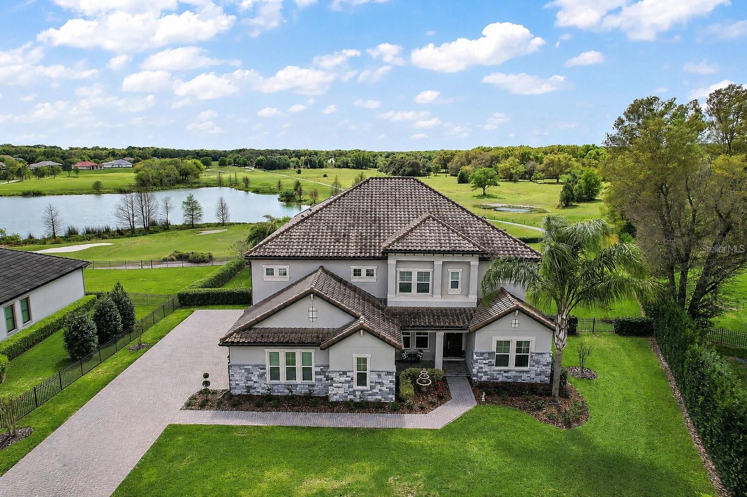 Perfectly positioned along the 4th hole of the prestigious RedTail Golf Club and overlooking the tranquil waters of Crossings Lake, this exceptional estate offers more than 5,200 square feet of refined living with spectacular golf and water views.

Designed for both elegant entertaining and everyday comfort, the thoughtfully crafted floor plan is filled with natural light and features expansive living areas, a private home office, formal dining room, soaring ceilings, and a dramatic staircase that creates an unforgettable first impression. A stunning fireplace serves as the centerpiece of the main living space, while oversized sliding glass doors seamlessly connect the indoors to the resort-style outdoor living area.

The home offers six spacious bedrooms and six full bathrooms, including two luxurious primary suites—one on each level—providing exceptional flexibility for multigenerational living or hosting long-term guests. Each suite features generous walk-in closets and beautifully appointed en-suite bathrooms designed with comfort and style in mind.

The gourmet kitchen is a chef's dream, showcasing premium appliances, granite countertops, custom tile backsplash, abundant cabinetry, a walk-in pantry, built-in microwave, glass cooktop, and an oversized island that makes entertaining effortless.

The main-level primary retreat offers a true spa-inspired experience with dual vanities, granite finishes, an oversized walk-in shower, a soaking tub, and an expansive walk-in closet.

Step outside and experience your own private oasis. The screened outdoor living space features a sparkling self-cleaning saltwater pool, spacious covered patio, lush landscaping, and panoramic views of the golf course and lake—creating the perfect backdrop for relaxing evenings, weekend gatherings, or simply enjoying the Florida lifestyle.

Located within the sought-after RedTail community, residents enjoy championship golf, scenic walking and biking trails, natural surroundings, and convenient access to dining, shopping, and entertainment throughout both Lake and Seminole counties.

Luxury, privacy, and timeless design come together in one extraordinary home. This is a rare opportunity to own one of RedTail's premier golf course estates.