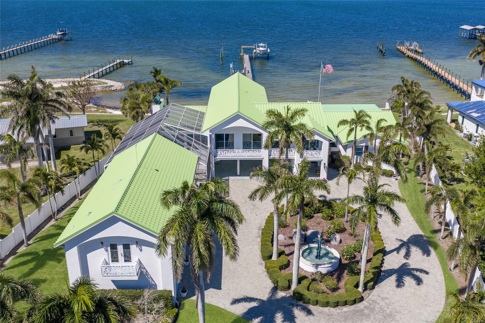 Under contract-accepting backup offers. EXTRAORDINARY IN EVERY DETAIL, this GATED RIVERFRONT ESTATE embodies the pinnacle of LUXURY WATERFRONT LIVING! Perfectly positioned on nearly three quarters of an acre along one of the widest stretches of the Manatee River, this artfully designed residence offers 5 bedrooms, 5.5 bathrooms including a private guest apartment, 7,679 square feet of living space, and over 11,000 total square feet, all curated with uncompromising craftsmanship. A private entry through a hand carved iron gate reveals a stunning courtyard with a custom fountain, setting a grand and inviting tone. Inside, refined architectural detail meets relaxed coastal elegance with soaring vaulted ceilings, solid core doors, porcelain tile, bamboo flooring, plantation shutters, and intricate custom millwork. Walls of glass frame sweeping river views, filling the home with natural light while seamlessly connecting indoor and outdoor living. The first floor primary suite is a secluded sanctuary, featuring a private library and an adjacent bedroom ideal for flexibility. The spa inspired bath is a true retreat with dual vanities, a soaking tub, an expansive walk in shower, and a custom designed walk in closet complete with built ins and a center island. An elevator provides seamless access to all levels, where additional bedrooms are generously sized and thoughtfully positioned for privacy. Multiple living areas offer incredible flexibility for a media room, fitness studio, office, or lounge spaces, allowing the home to adapt effortlessly to any lifestyle. The detached guest house further enhances the estate with its own living room, kitchenette, and oversized ensuite bedroom, creating a private and comfortable retreat for visitors. Outdoor living unfolds like a tropical resort. Multiple balconies and screened terraces capture panoramic views across the mile wide river, while the gorgeous pool and spa are surrounded by lush tropical landscaping, creating a serene and secluded oasis. A rare white sandy beach along the river’s edge enhances the setting, offering a truly coastal experience rarely found on the Manatee River. The deep water dock is equipped with two boat lifts and provides direct access to Tampa Bay and the Gulf, ideal for boating, fishing, and sunset cruises right from your backyard. Additional features include a generator, a 3 car garage, and an additional 3 car carport providing ample space for vehicles and guests. A rare offering on one of Bradenton’s most prestigious riverfront addresses, this estate delivers an unparalleled blend of privacy, scale, and resort style living—where every detail is intentional and every day feels like a waterfront escape!