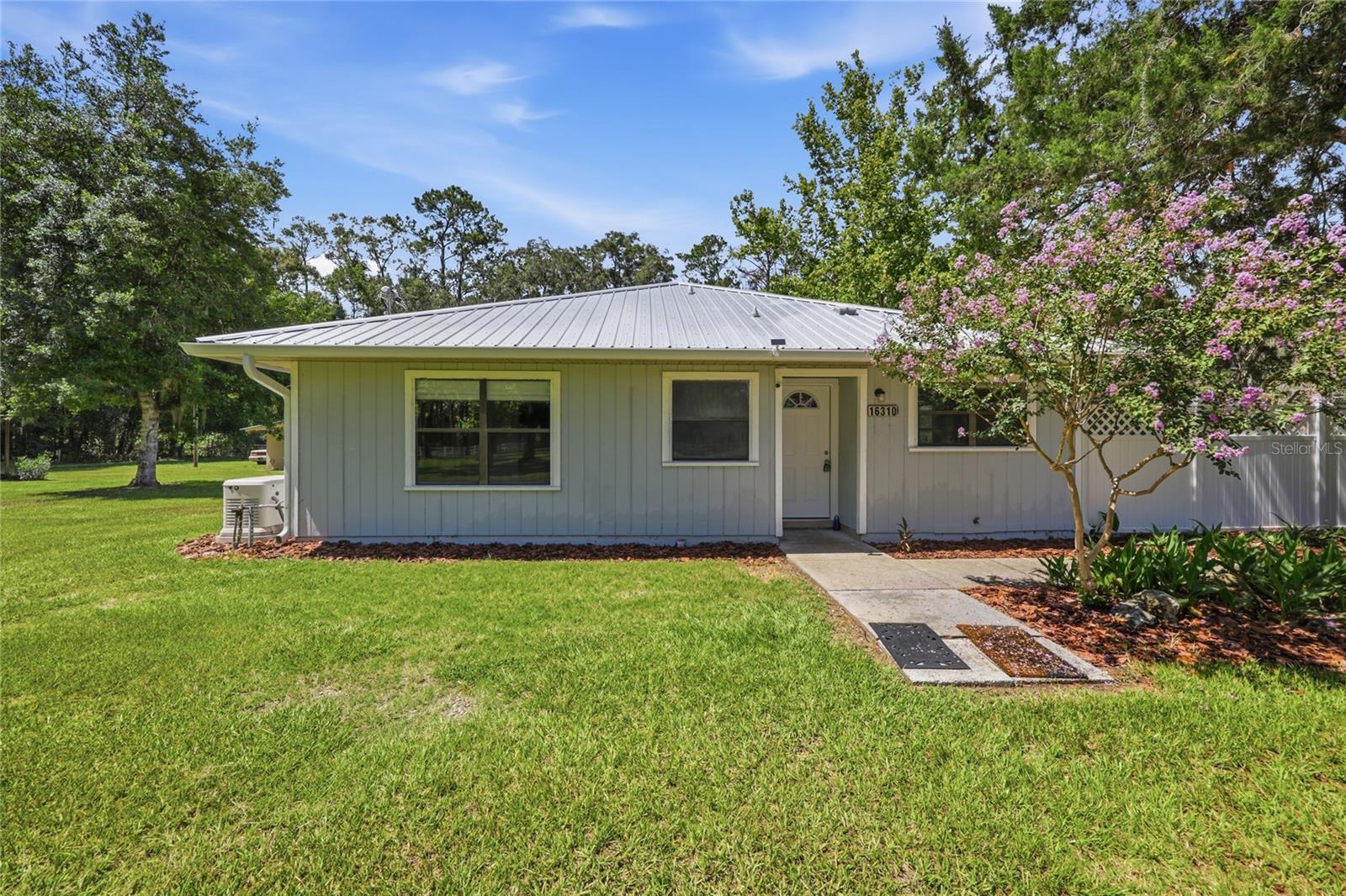 Virtually Staged. Private 5-Acre Country Estate with Guest House, Pole Barn & modern updates. Every property has a story, and this one begins with the beauty of North Florida—majestic oak trees, breathtaking sunsets, and the peaceful charm of country living. Welcome to your own private retreat on 5 beautiful acres.  Offering the perfect combination of privacy, flexibility and modern updates-all just minutes from Newberry, Alachua, and Gainesville. This unique property features 2,027-square-foot main home with 2 bedrooms, 2 bathrooms, and a bonus room along with a detached 1-bedroom, 1-bath guest house complete with its own kitchen and living area. Whether you're looking for multigenerational living, a private home office, guest accommodations, or additional space for family, this property offers exceptional flexibility. Move-in ready with over $30,000 in recent improvements, including fresh interior paint, new flooring, updated electrical work, new seamless gutters, landscaping, and numerous repairs, allowing you to enjoy the property from day one. Zoned Agricultural (AG), the property is ideal for horses, livestock, gardening, or creating your own hobby farm. Major updates include: New Metal Roof (2018), Two HVAC systems (2019), Generac whole-house generator (2020), Additional septic system and drain field (2021).  Outdoor Amenities include: 30'X36' pole barn with electricity, Two EV charging hookups, Four storage buildings, Large two-story storage building/workshop, fire pit, plenty of room for RVs, boats, trailers, and recreational equipment. This one-of-a kind property offers the peaceful lifestyle you've been looking for without sacrificing convenience. Whether you're searching for a family homestead, hobby farm, private country retreat, or simply room to spread out and enjoy nature, this exceptional property is ready to welcome its next owners.