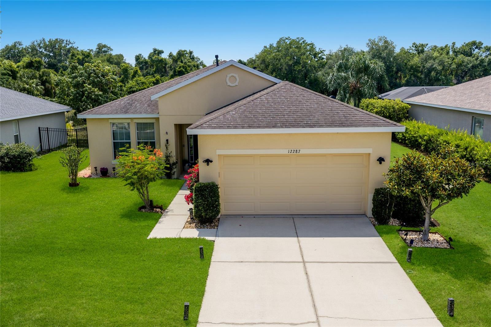Welcome to 12287 Lavender Loop! With 2,136 square feet of one-level open-concept living space, this waterfront pool home sits tucked inside the 24-hour manned gates of the picturesque community of Greyhawk Landing. As you enter through the front door, you're immediately welcomed with unmatched natural light throughout, rear western exposure and large sliding doors that open directly onto the screened lanai and heated pool. The eat-in kitchen has been refreshed with white cabinetry, new cabinet and drawer hardware, upgraded stainless-steel appliances, a luxury induction cooktop, an under-sink water filtration system and under and above-cabinet lighting that warms the space at every hour. Additional notable upgrades include a brand-New shingle roof being installed in May 2026) a 2023 HVAC, a 2022 gas pool heater, whole-home hurricane shutters, updated landscaping and a newly painted front door. This home is also smart-home ready. Conveying with the property are Ring security cameras and doorbell, a Nest thermostat, Rachio smart irrigation, a smart garage opener, a smart pool timer, as well as wired fiber-optic internet. In front of the home, you'll find a large, versatile den/bonus room, upgraded with a double-door entry that works beautifully as a home office, playroom or guest space. The 14-by-19-square-foot. primary suite is its retreat, boasting beautiful tray ceilings, a private set of sliding glass doors for easy lanai access and a peaceful seating area below the oversized picture windows. As you enter the primary en-suite, you'll find dual walk-in closets, separate double vanities, a private water closet and a glass-enclosed walk-in shower with an integrated garden soaking tub. Two additional bedrooms share a well-appointed full bath at the opposite end of the home, with a convenient half bath off the main living area for guests. Outside, enjoy the screened lanai, equipped with a gas grill hookup for your future outdoor kitchen dreams. The backyard views only get better as the sun goes down and cotton-candy skies arrive nightly over the pond and the private preserve beyond. Life inside the resort-style community of Greyhawk Landing means two clubhouses with heated lagoon-style pools and spas, multiple children's splash zone areas, a spacious fitness center, tennis, pickleball, basketball courts, soccer and baseball fields, a fishing pier and nearly two miles of recreational and biking trails, all behind a guard-gated entry and one of the lowest HOA's in the area. Greyhawk Landing is in an A-rated school district and is minutes to the UTC Mall, Waterside at Lakewood Ranch, multiple hospitals and medical facilities, Interstate 75, golf courses/sports complexes as well as some of the top Gulf Coast beaches. Schedule your private showing today!