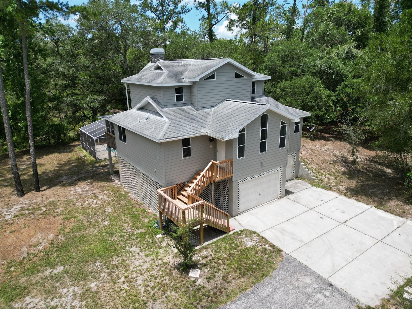 Discover the perfect blend of privacy, natural beauty, and exceptional waterfront living with this one-of-a-kind stilt home offering an impressive 231 feet of frontage on the Withlacoochee River. Nestled on 6.31 secluded, zoned agricultural, this property provides the peaceful lifestyle you've been searching for while offering plenty of space for recreation, hobbies, or simply enjoying nature. A paved driveway welcomes you to the home, where you'll find an oversized 3-car garage with room to accommodate up to 5 vehicles, making it ideal for cars, boats, ATVs, or workshop space. Outside, relax year-round in the screen-enclosed swimming pool or unwind on the screened lanai just off the kitchen and dining area, perfect for entertaining family and friends. Inside, the spacious living room is centered around a cozy gas fireplace and opens to a deck overlooking the sparkling pool and breathtaking river views. The thoughtfully designed layout places the private primary suite on the third floor, complete with its own outdoor deck where you can enjoy morning coffee, stunning sunsets, and peaceful views of the Withlacoochee River. Whether you're looking for a full-time residence, a private retreat, or a waterfront escape with room to grow, this exceptional property offers a rare combination of acreage, privacy, and riverfront living. Additional features include county water, septic system, and providing flexibility and convenience in an idyllic natural setting. Experience the wildlife sanctuary and tranquility of riverfront living while remaining within easy reach of everyday amenities. Opportunities like this are few and far between—schedule your private tour today!