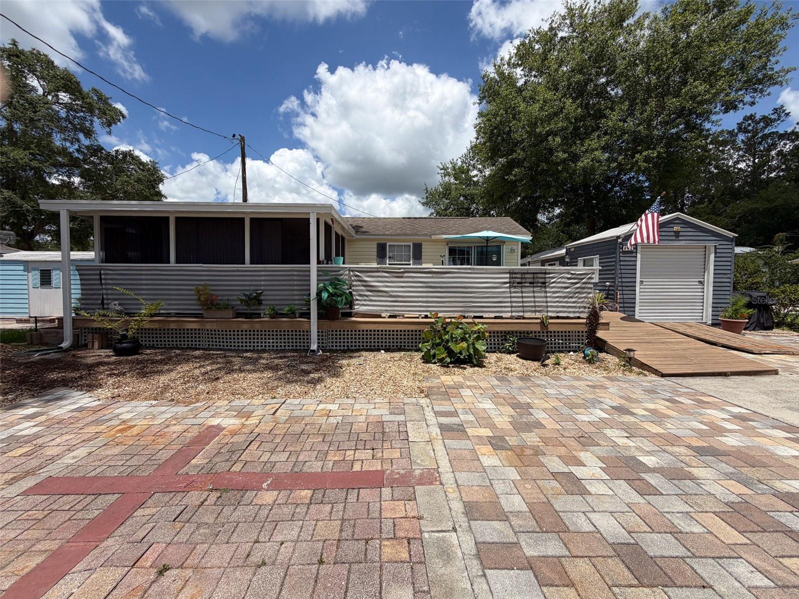 Absolutely adorable Tiny Home in beautiful Campers Holiday, Brooksville Florida.  Paradise just may be Campers Holiday, where you own your land.  In this case, it's a 60x60 homesite, and here you enjoy all the wonderful amenities; clubhouse, sparkling Community Pool (directly across the street), manicured and landscaped common areas, plus secure manned gated entry, all for low HOA fee.  Golf carts are welcome!  And, being 55+, you're among the "active retired", loving the Florida lifestyle!  Perfect for snowbirds or year-round residents.  This "park model" is 2008 construction, with vaulted ceilings inside, new zoned mini-split HVAC, luxury vinyl plank flooring, light and bright cabinetry, full appliance package, ceiling fans, smart-design closets and storage, easy care finishes and lots of natural light.  Outside, the enclosed porch is roomy, adding more relaxation space adjacent to the open deck.  Brick pavers add a luxurious touch to the exterior and make great curb appeal as well as plenty of parking!  The attached Golf Cart Garage does triple duty as workshop and laundry (stackable washer/dryer package included), it's air conditioned too!  There's even a whole-house pre-wired Generator set up in case of a weather related black-out.  Property is high and dry, no flood insurance required.  This is a premier home in Campers Holiday, ready for you to enjoy the good life.