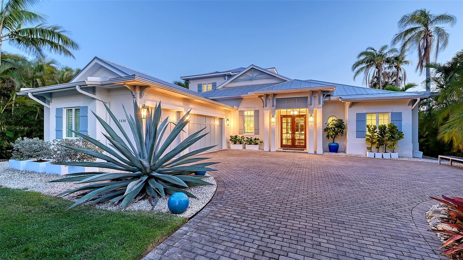 One or more photo(s) has been virtually staged. Welcome to The Islamorada—a 2017-built coastal contemporary residence by Heritage Builders, ideally located in the highly sought-after Oyster Bay neighborhood of Sarasota. Blending expert craftsmanship with elegant design, this exceptional home offers the rare combination of luxury, privacy, and convenience—just moments from The Field Club, Siesta Key Beach, and the cultural heart of downtown.
Step inside to soaring vaulted ceilings, expansive windows, and a warm, transitional aesthetic that exudes both comfort and sophistication. The thoughtfully designed open floor plan flows effortlessly from the spacious great room to the dining area and gourmet kitchen—perfect for entertaining or relaxing in style.
The chef’s kitchen is a showpiece, outfitted with JennAir Pro Series stainless steel appliances, full-height designer backsplash, custom cabinetry, and a walk-in pantry.
The main-level primary suite is a private retreat, featuring dual walk-in closets and a spa-like bath with separate vanities, a freestanding soaking tub, and a glass-enclosed shower with dual shower heads, a bench seat, and designer tile details. Also on the first floor are a guest bedroom and a versatile office or den. Upstairs, a generous bonus room and two additional bedrooms provide ideal accommodations for family or guests.
Step outside and enjoy the best of Florida living. The screened lanai offers travertine pavers, a custom pool with sun shelf, gas-heated spa, and a full outdoor kitchen with built-in grill and exterior-grade cabinetry. Hurricane-rated electric roll-down screens, a whole house generator, and a 500-gallon propane tank offer year-round peace of mind and comfort.
Every detail has been thoughtfully curated with high-end finishes throughout: wide-plank hardwood floors, porcelain tile, plush carpeting, 8’ solid-core interior doors, impact-rated Low-E insulated windows, custom wood cabinetry, and a stunning mix of quartz and granite countertops. The oversized three-car garage is complete with insulated doors and epoxy flooring.
Located West of the Trail in one of Sarasota’s most desirable communities, this home offers unmatched quality, comfort, and coastal charm.
