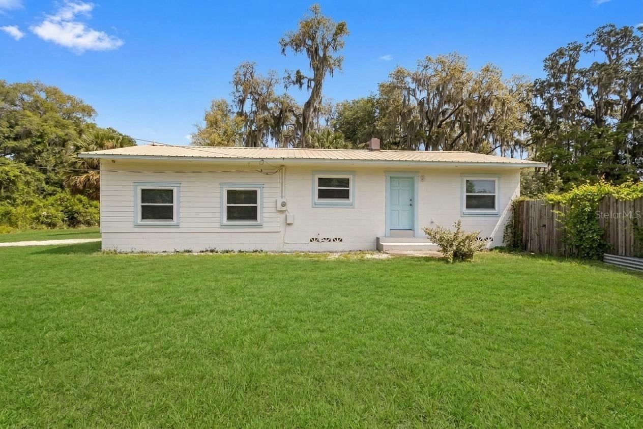 Check out this cute 2 bedroom, 1 bath, 1 car carport,  block home on over a half acre near Downtown Deland!  All the hard work has been done for you!  This home is completed upgraded with a new kitchen, beautifully tiled bathroom, and laminate floors throughout.  The roof is a metal roof and the windows were replaced in 2023.  The carport could also be used as a large covered porch and there is an interior laundry. Walking into this home you have a sense of coziness and cleanliness.  It has been very well maintained and is ready for its next person/family!