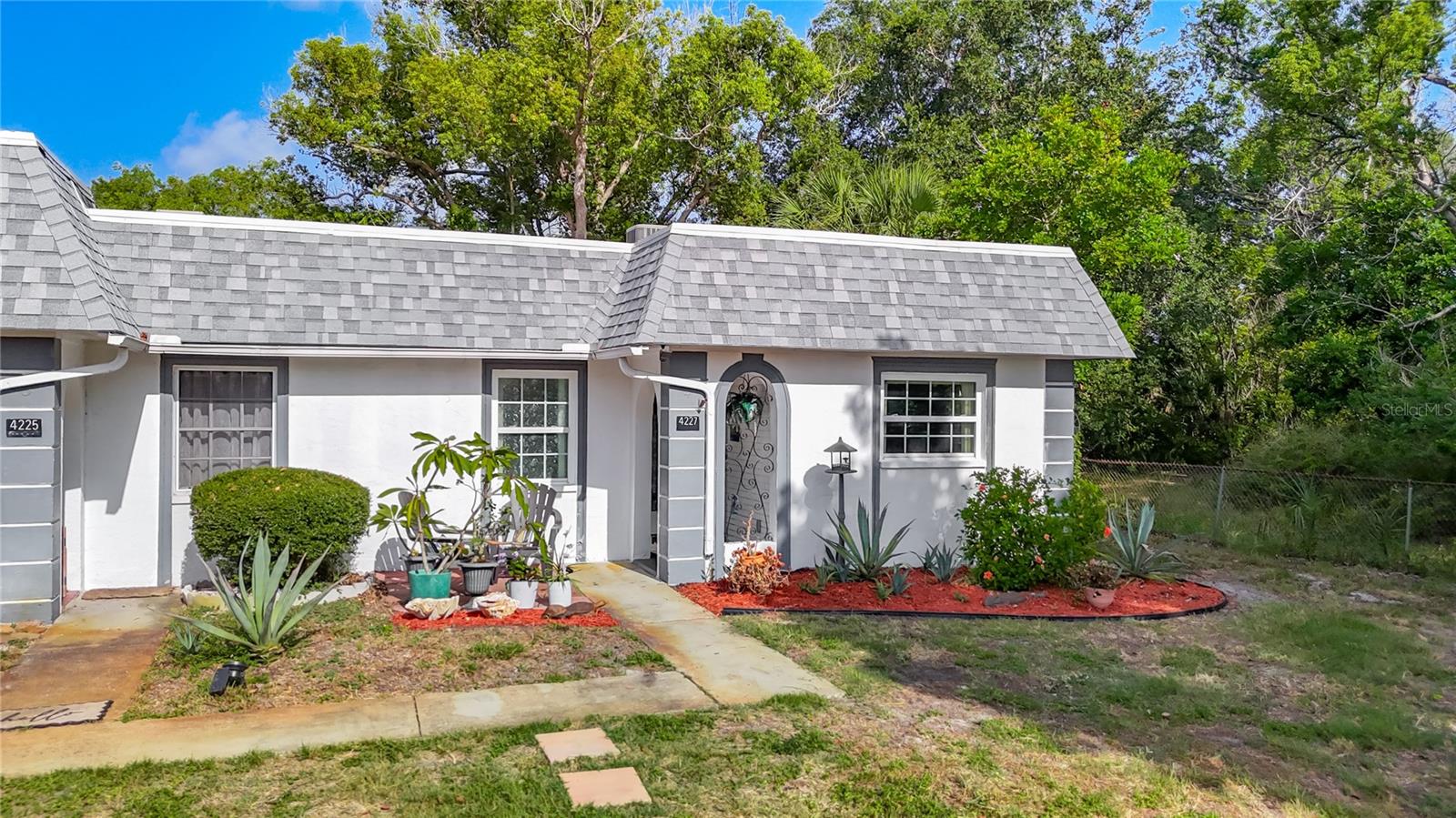 Welcome to  maintenance-free living in this, no age restriction, beautifully remodeled, freshly painted, 2-bedroom, 2-bath end-unit condominium, on a tranquil canal with egrets, cranes, turtles and a nature preserve that provides shade, enhanced privacy and songbirds to brighten your day.  Enjoy your coffee on the front patio and listen to the birds, eat breakfast on the back patio and feed the numerous turtles, take a break during the day and fish for sea bass in your back yard under the shady oak tree, BBQ with friends at the patio table overlooking both the canal views and the nature preserve, or garden on the side of the unit. From the moment you enter, you'll appreciate the home's coastal-inspired décor and airy feel. The rooms seamlessly flow into each other with larger light grey tile  throughout. The remodeled kitchen showcases elegant faux marble quartz countertops, updated white cabinetry, modern finishes, and newer appliances. The condo has a newer A/C, updated electrical, and a newer, full sized, stacked, blue washer and dryer. The open concept spacious dining and living areas draw you right to the enclosed Florida room, where you can enjoy serene canal views year-round. This versatile space serves as the perfect spot for morning coffee, relaxing with a book, or hosting guests while enjoying the peaceful waterfront backdrop. The master suite offers direct access to the Florida room, a window overlooking the preserve and an en-suite bathroom. The bathroom offers a remodeled shower with large faux white marble tiles set vertically, white cabinets, a white quartz countertop and a teal shell inspired glass vessel sink. The generously sized guest bedroom is bright and airy with views of the tree filled preserve from both windows. The guest bathroom offers a remodeled bathtub with large wavy white tiles, custom navy cabinets, a white quartz countertop with a custom navy glass vessel sink with swimming dolphins.  
Additional features include palm bladed ceiling fans in the living room, Florida room, and both the bedrooms. The kitchen and bathrooms have whisper quiet yet powerful white fans. Assigned parking is conveniently located  just steps from the condo, with guest parking right next to it. The roof and mansard are newer, the pool area has been refreshed, the clubhouse is available for residents, and there are a variety of social activities. The monthly condominium fee includes cable, water, trash removal, lawn maintenance, roof maintenance, exterior maintenance, pest control and flood insurance. Conveniently located 10 minutes from Anclote Park with it's beautiful beach area, nature trails, dog park, covered pavilions, and boat  ramps. Only 45 minutes from Tampa International Airport and Clearwater Beach,  near shopping, dining, entertainment, medical facilities, parks, golf courses, marinas, boating, and several of Florida's beautiful Gulf beaches, including the iconic Honeymoon Island and the picturesque Sunset Beach. Just off of US Highway 19 and State Road 54. Whether you're seeking a full-time residence, a seasonal getaway, or a retirement retreat, this move-in-ready waterfront condo offers the perfect blend of comfort, style, and convenience. You can also purchase the furniture and then all you have to bring is your tooth brush and your bathing suit to begin experiencing the best of Florida living.