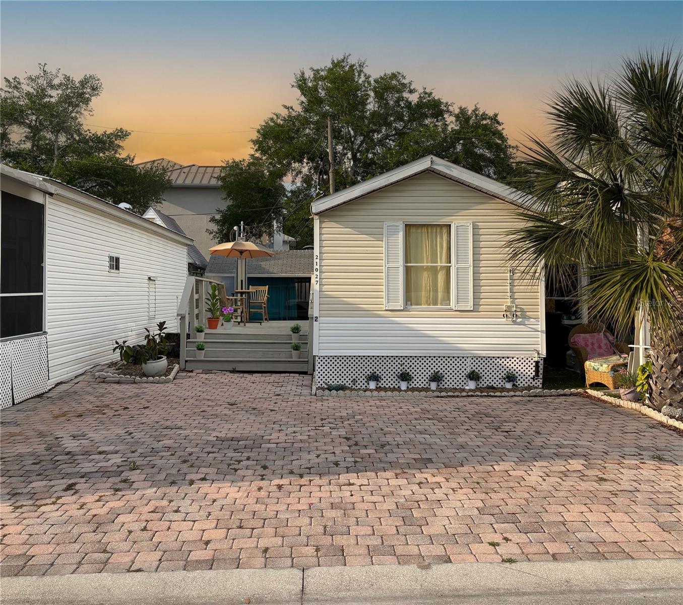 Experience relaxed resort-style living in Paradise Lakes, a vibrant gated nudist community north of Tampa. With a low HOA of just $35/month, this property offers excellent value!  This 2 bedroom, 1.5 bath manufactured home features an open-concept layout with a split-bedroom design for added privacy. Recent updates include laminate flooring, fresh interior paint and ceiling fans throughout.  The home is partially furnished, making it move-in ready or ideal for seasonal use. Sliding glass doors open to a spacious deck, perfect for relaxing or entertaining. The deck connects to a three-car paver driveway and can be screened in if desired. An oversized storage shed provides space for storage, a workshop, hobby area, or home office.
Conveniently located near the clubhouse and laundry facilities, the home offers easy access to community amenities. Optional resort membership includes multiple pools, a hot tub, fitness center, pickleball and sand volleyball courts, plus a tiki bar, sports bar, nightclub, and on-site dining.
Additional features include a roof installed in 2019 and regular termite inspections.
Whether you’re looking for a full-time residence, seasonal retreat, or investment opportunity, this property offers great potential. Schedule your showing today! Call for access to this gated community and to view the property.
