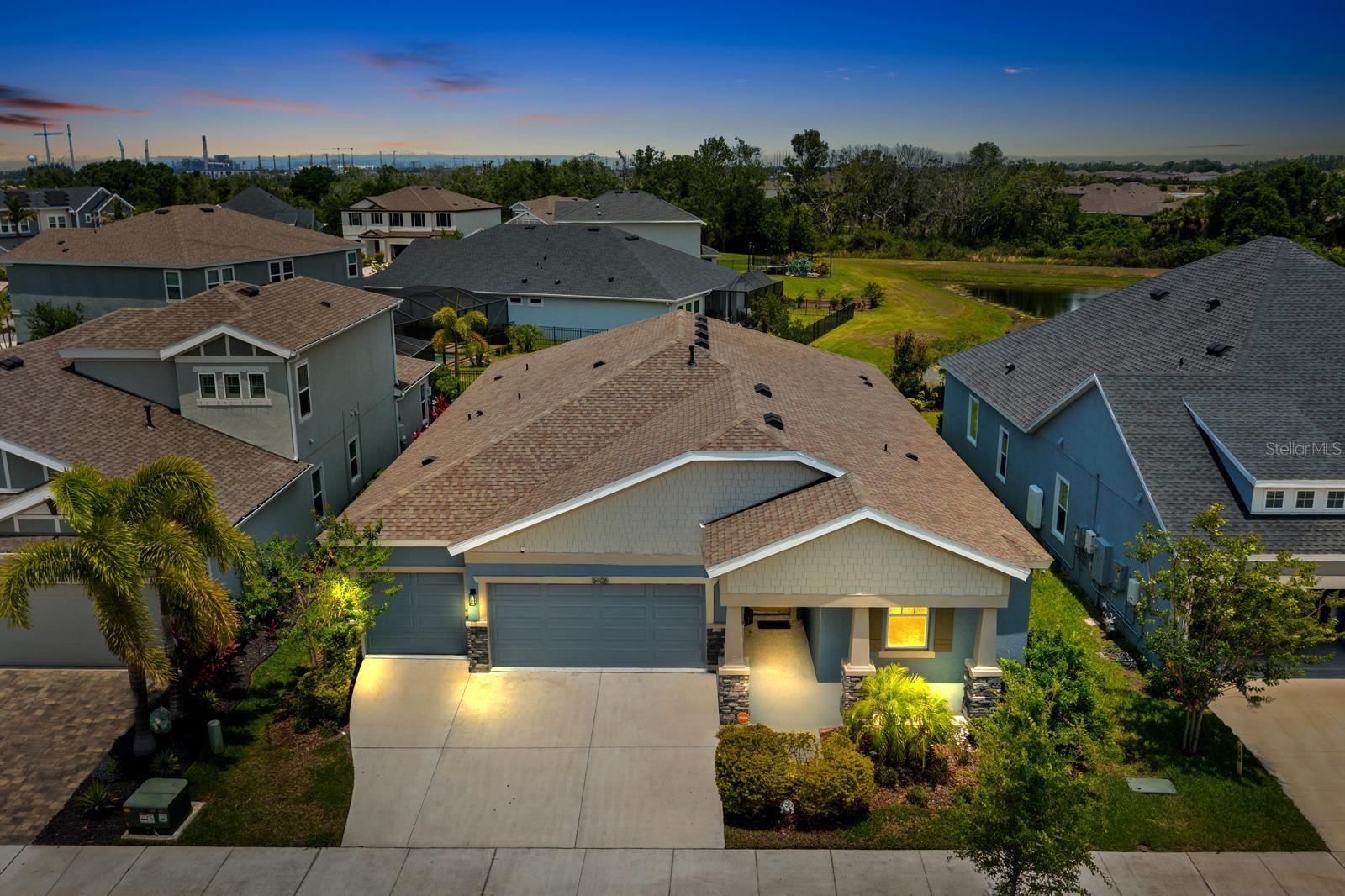 Welcome to this beautifully designed, modern residence located in the award-winning, master-planned community of Waterset in Apollo Beach, Florida. Built in 2023, this meticulously maintained single-story home blends contemporary design, an expansive open-concept floor plan, and vibrant resort-style neighborhood living. Situated on a professionally landscaped homesite, the exterior showcases exceptional curb appeal highlighted by clean architectural lines, an inviting covered front porch, and an attached two-car garage. The property features a private rear covered patio, offering a wonderful setting for outdoor relaxation, dining, and entertaining in the ideal Florida climate. Inside, the home offers approximately 2,174 square feet of heated living space defined by high ceilings, abundant natural light, and a thoughtfully planned layout designed for both everyday comfort and effortless entertaining. The expansive great room serves as the heart of the home, flowing seamlessly into a chef-inspired gourmet kitchen. Perfect for culinary enthusiasts, the kitchen is equipped with a large center island, an integrated breakfast bar, premium stone countertops, a spacious walk-in pantry, and a high-end appliance package that features a built-in oven, convection oven, and a natural gas cooktop. The primary suite serves as a luxurious private retreat, strategically positioned to ensure maximum privacy. This spacious suite features a generous walk-in closet and a spa-inspired ensuite bathroom complete with dual vanities, modern finishes, and a large walk-in shower. Three additional well-appointed bedrooms feature built-in closets and ceiling fans, sharing easy access to the second full bathroom- offering the perfect setup for family, guests, or a dedicated remote home office. Additional high-end features and upgrades include energy- efficient natural gas heating, an indoor utility laundry room, custom window blinds, and modern low-maintenance flooring through the main living areas. Residents of the highly sought-after Waterset community enjoy access to unparalleled resort-style amenities, including multiple swimming pools, a splash pad, a community clubhouse, a neighborhood café, a state-of-the-art fitness center, dog parks, playgrounds, and courts for tennis, pickleball, and basketball, alongside miles of scenic walking and biking trails. Conveniently located for an easy commute to downtown Tampa, MacDill Air Force Base, local waterfront dining, and beautiful Gulf beaches, this Apollo Beach home offers the perfect blend of modern luxury and an active coastal lifestyle.