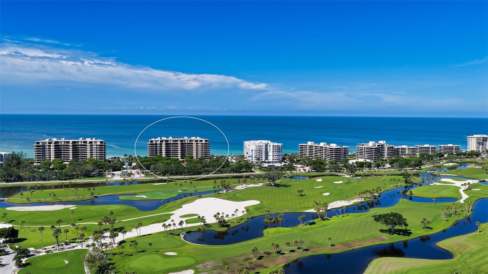 There are views… and then there is this view! From this desirable seventh-floor corner residence at L’Ambiance, the horizon unfolds in a breathtaking panorama—Gulf of Mexico sunsets ablaze to the west, Sarasota Bay shimmering to the east, the downtown skyline sparkling in the distance, and the manicured fairways of the Longboat Key Club Island side golf course below. Morning light and evening color become part of daily life, ever-changing and endlessly captivating. The arrival to this luxurious community, sets an immediate tone of distinction. A fountain-lined drive and 24-hour manned gate lead to a secured building where a full-time concierge delivers an unrivaled level of service. From welcoming guests to coordinating deliveries and attending to daily conveniences, the care and professionalism here is unrivaled. An elevator opens directly to your private foyer with double doors, revealing architectural details that add warmth and refinement—pecky cypress ceiling accents, a gracious dry bar, custom built-ins, soft cove lighting, and walls of glass that frame the surrounding water views. Expansive wraparound terraces extend the living spaces outward, creating an extraordinary setting for sunset dining, morning coffee, or effortless entertaining against a backdrop of sea and sky. The kitchen is thoughtfully appointed. The center prep island includes its own auxiliary refrigerator and freezer drawers—ideal for entertaining—while the breakfast nook overlooks the water and opens directly to the terrace. The spacious open living and dining areas are bathed in natural light, designed to showcase both the views and today’s modern lifestyle. This well-designed two-bedroom, two-and-a-half-bath residence lives beautifully—and is complemented by a significant advantage: reservable guest suites located just downstairs. Your visitors enjoy private, comfortable accommodations within the building, allowing you to preserve the serenity and elegance of your own home while hosting with ease. The split-bedroom floor plan enhances privacy, with the primary suite positioned to capture sweeping Gulf views. Recently enhanced with an oversized custom-fitted closet, it offers both luxury and thoughtful functionality. A full-sized laundry room, a rear service entrance, motorized blinds and draperies throughout, private parking, a storage unit, and a wine locker complete this exceptional offering. Residents of L’Ambiance enjoy resort-caliber amenities including a beachfront pool with cascading waterfalls, two Har-Tru tennis courts, a state-of-the-art fitness center, elegant social rooms, guest parking, and direct beach access. Just a couple of minutes away, world-famous St. Armand's Circle and over the Ringling bridge to everything downtown Sarasota has to offer.... fine dining, boutique shopping, and cultural attractions. Optional membership at the exclusive Longboat Key Club provides access to championship golf, premier tennis, several restaurants, boating facilities, and an active social calendar. This is more than a condominium—it is a private coastal sanctuary supported by impeccable service, refined amenities, and one of the most commanding vantage points on Longboat Key.