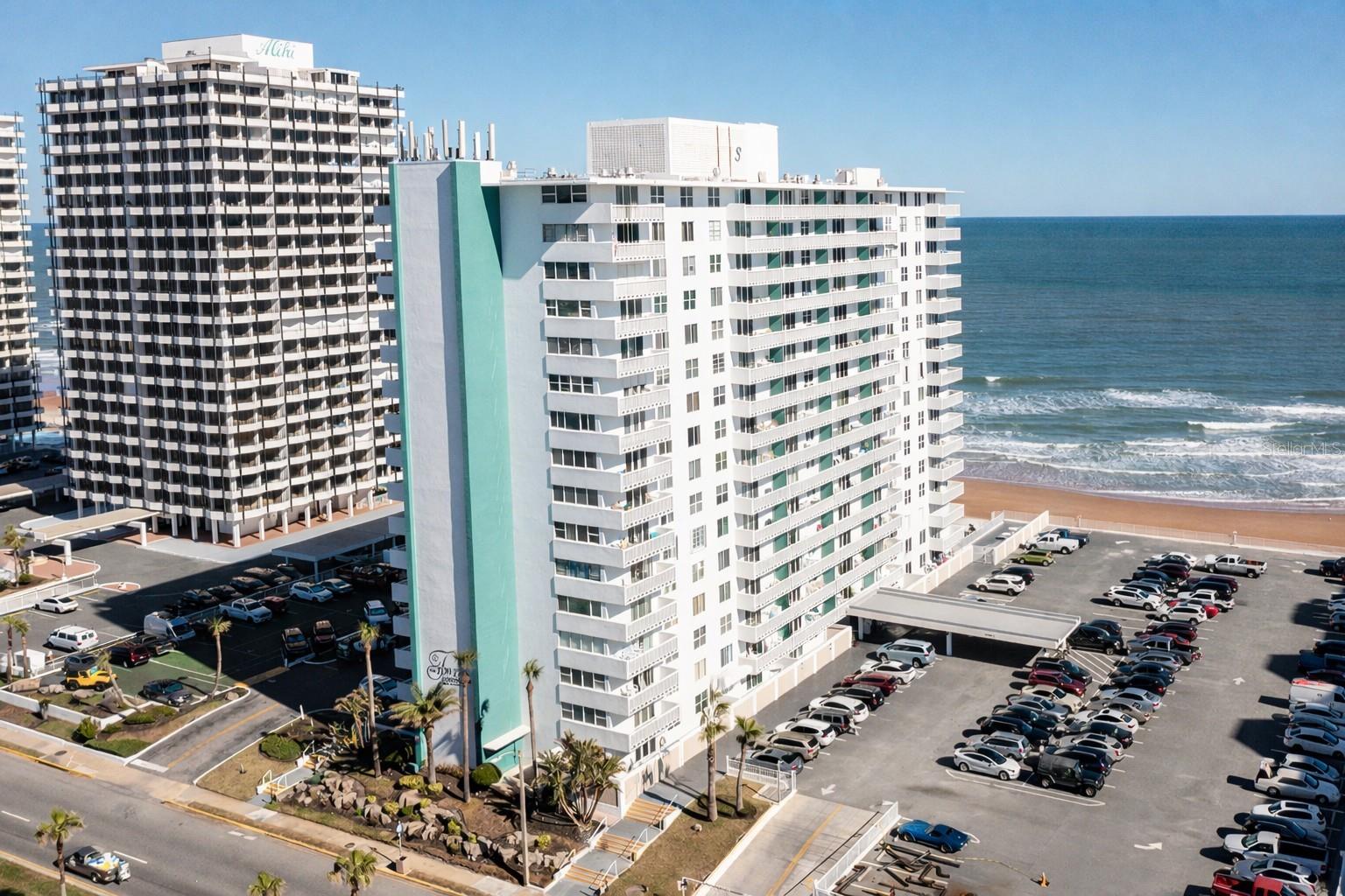 Experience elevated coastal living in this beautifully renovated 14th-floor, one-bedroom, one-bath oceanfront condo offering sweeping ocean, Intracoastal, and city views from an expansive 30-foot balcony. Filled with natural light and thoughtfully redesigned, this move-in-ready residence blends modern style with relaxed beachside charm. The open-concept living space features luxury vinyl plank flooring, plantation shutters, updated lighting, and a fresh designer palette throughout. The custom kitchen is a true showpiece with Coastal Sage soft-close cabinetry, warm butcher block countertops, sleek white glass appliances, a hidden panel dishwasher, open shelving, matte black fixtures, and a spacious breakfast bar that flows seamlessly into the living and dining areas. The spacious bedroom offers peaceful ocean views, remote-controlled blinds, generous storage, and a calming retreat after a day at the beach. The renovated bath complements the home's modern coastal aesthetic with stylish finishes and thoughtful details. Located in a sought-after oceanfront building with direct beach access, residents enjoy a gated entrance, swimming pool, fitness center, BBQ area, laundry facilities, storage, cable, internet, water, trash service, and abundant surface parking. With 30-day minimum rentals permitted and two pets under 25 pounds allowed, this property offers outstanding flexibility whether you're searching for a full-time residence, seasonal escape, or investment opportunity. Conveniently located near Publix, restaurants, shopping, entertainment, and just minutes from Ormond Beach, this beautifully updated condo delivers the Florida lifestyle you've been looking for.