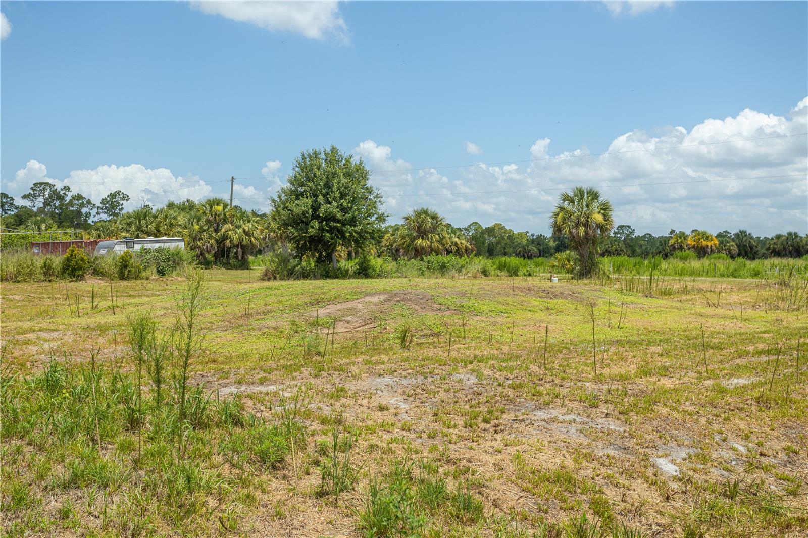 Build your dream home on this beautiful, cleared 1.25-acre homesite in the highly sought-after Charlotte Ranchettes community of Punta Gorda. Already prepped with valuable improvements, this property is ready for your vision and offers significant savings in time and development costs. The property features a 270-foot deep well installed in 2024 with all equipment professionally mounted on a concrete pad, a septic system installed in 2025, and two electrical poles located just outside the property, ready for utility activation. Also included are two 40-foot shipping containers, providing ample storage during construction or the perfect foundation for a future workshop or outbuilding. Enjoy the peace and privacy of country living with plenty of room to design the lifestyle you've always wanted. With no HOA fees or deed restrictions, you'll have the freedom to create your own private retreat with space for recreational vehicles, animals, gardens, hobbies, and more. This property offers the best of both worlds—quiet rural living with convenient access to Punta Gorda's shopping, dining, entertainment, parks, and waterfront attractions. Gulf Coast beaches, excellent schools, and both Punta Gorda Airport and Southwest Florida International Airport are just a short drive away. As an added bonus, you'll even have the opportunity to enjoy views of the Punta Gorda Air Show from the comfort of your own property. Don't miss this rare opportunity to own a build-ready acreage parcel with major improvements already in place.