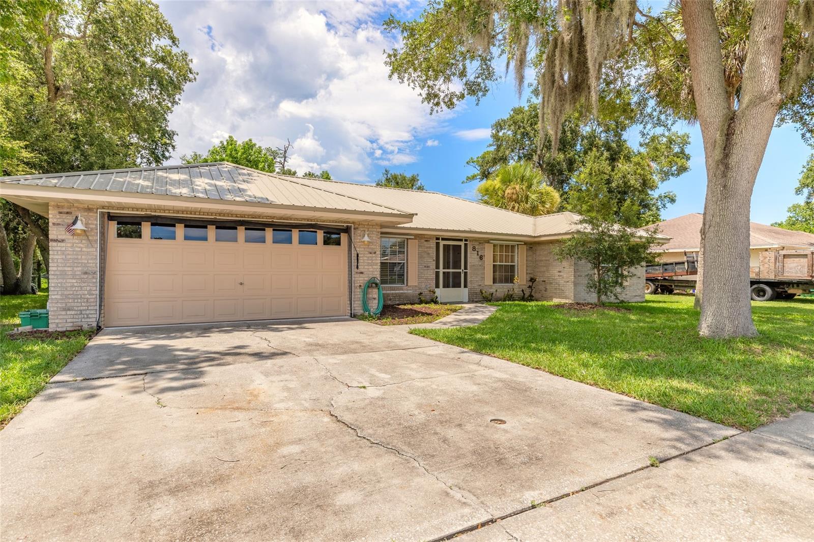 Welcome home to this well-maintained property offering a fantastic central location close to schools, shopping, medical facilities, the beach, golf courses, and International Speedway Boulevard. Designed with families in mind, this home features a spacious floor plan with high ceilings, a formal dining room, separate living and family rooms, and a desirable split-bedroom layout that provides added privacy. The galley-style kitchen includes a cozy breakfast nook, along with a newer stove and dishwasher, making it both functional and inviting. The generous owner's suite offers a walk-in closet and a spacious en suite bathroom with an updated walk-in shower. Additional highlights include an interior laundry room, an oversized garage, hurricane shutters, and a durable metal roof installed in 2023 and newer water heater and AC for added peace of mind. The home is in good condition and offers the perfect opportunity for its next owner to add their personal touch and make it their own. Outside, you'll find a spacious yard with plenty of room for entertaining, gardening, or family activities.